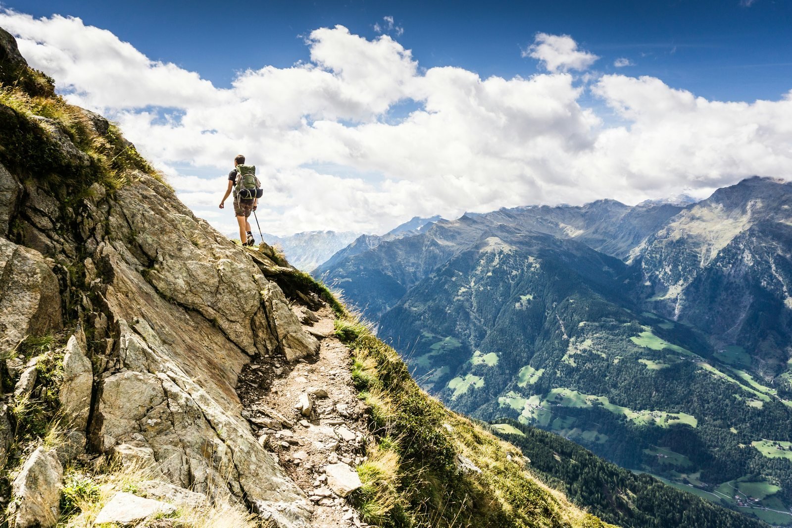 Hiker climbing a steep alpine mountain trail, symbolising the challenging but achievable path to FIRE for late starters.