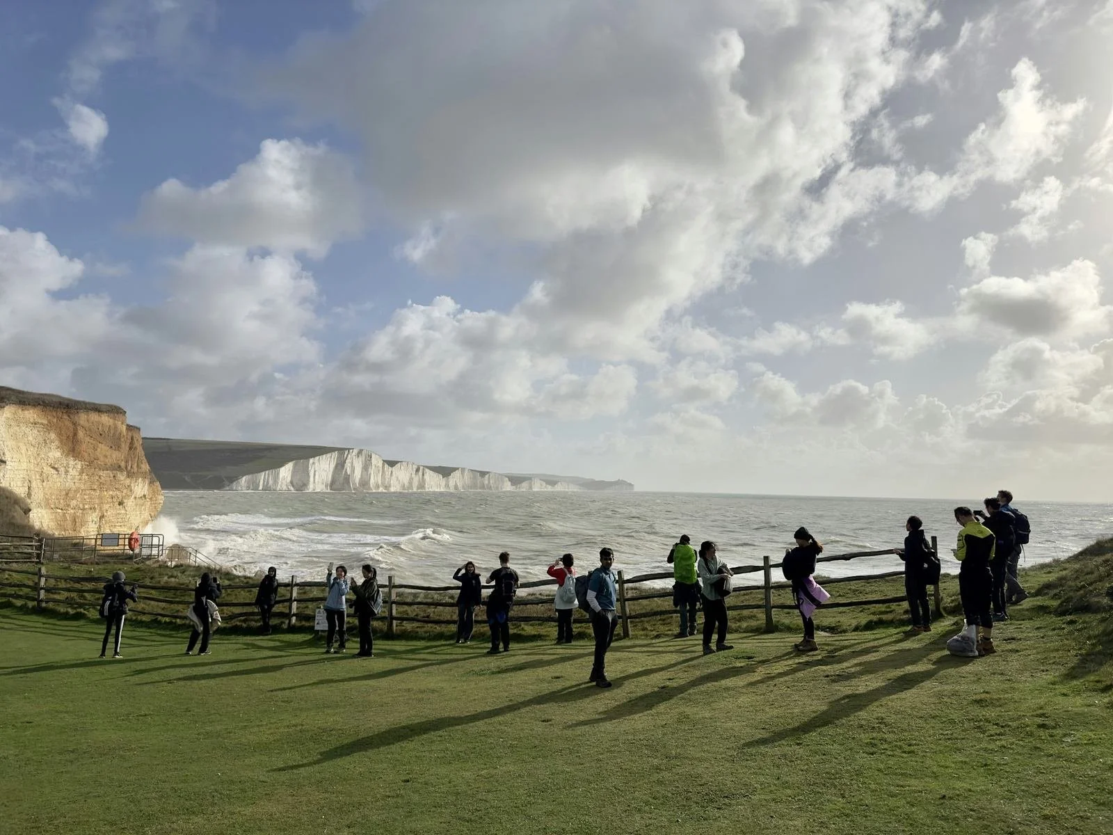Group standing together near a coastal path—illustrating the role of community and social structure after retiring early.