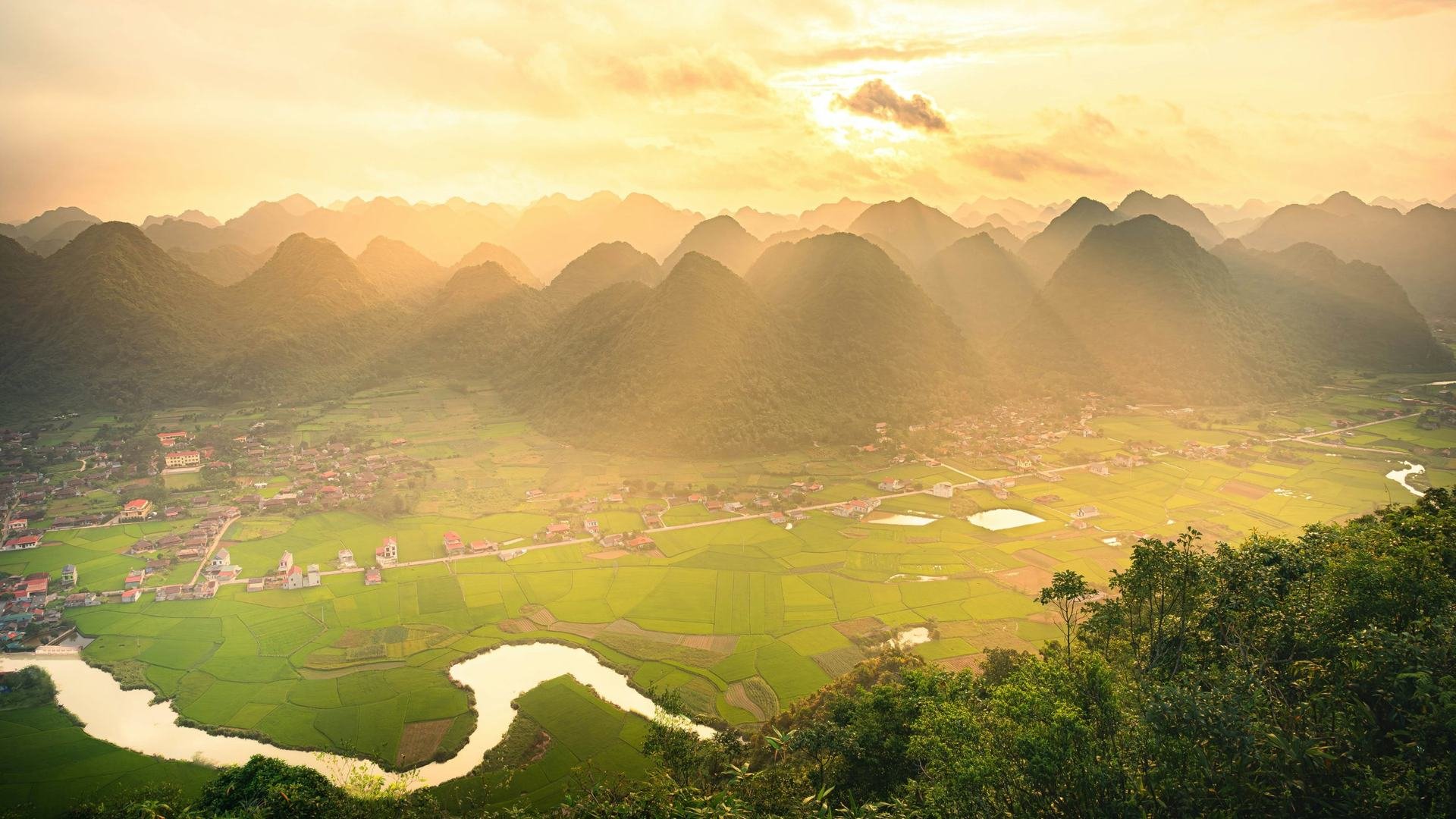 Sunrise over a green mountain valley, illustrating the bull case for stocks and long-term optimism.