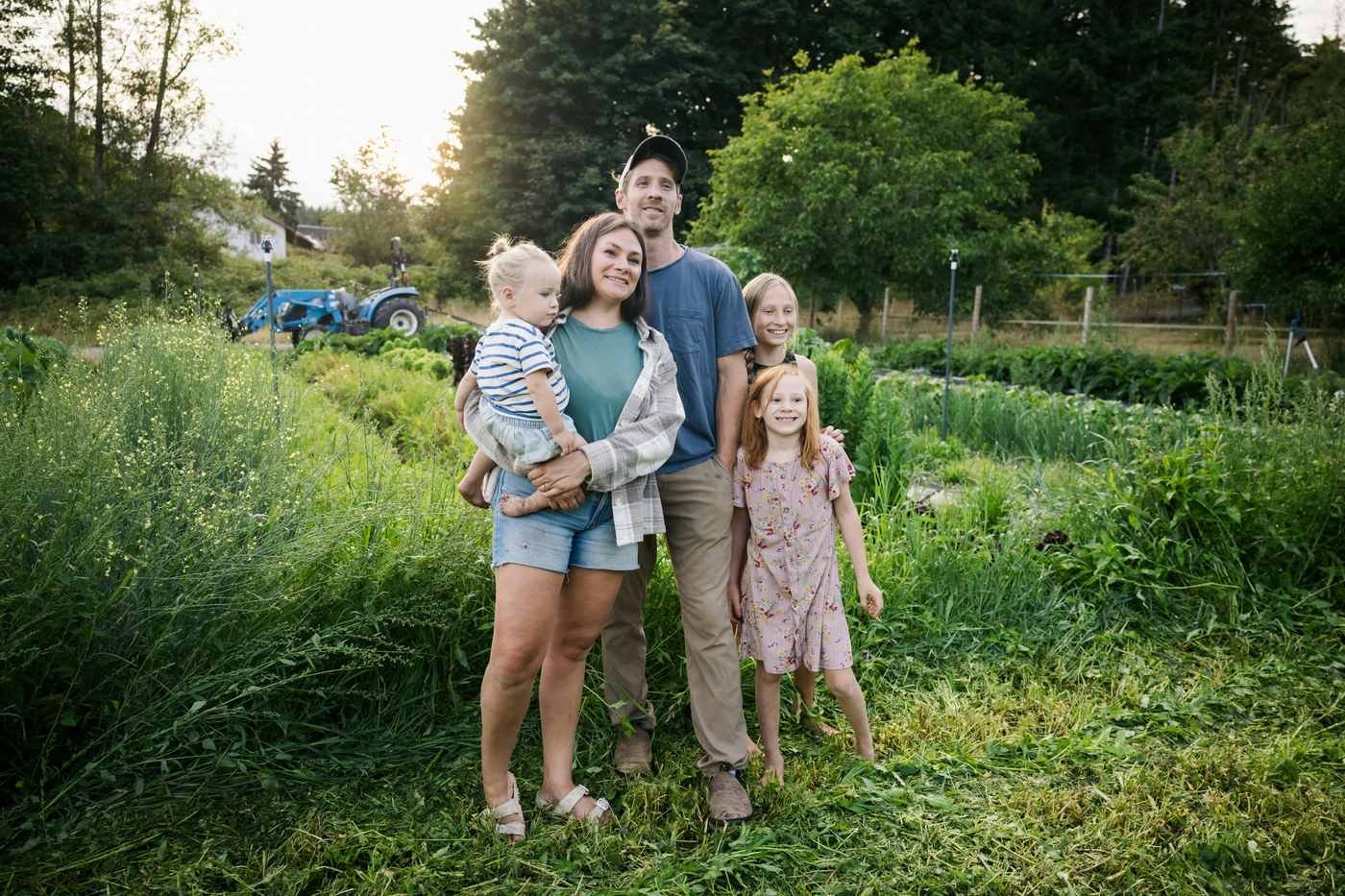Family with young children outdoors on a farm in summer — slow travel and intentional living on the path to financial independence.