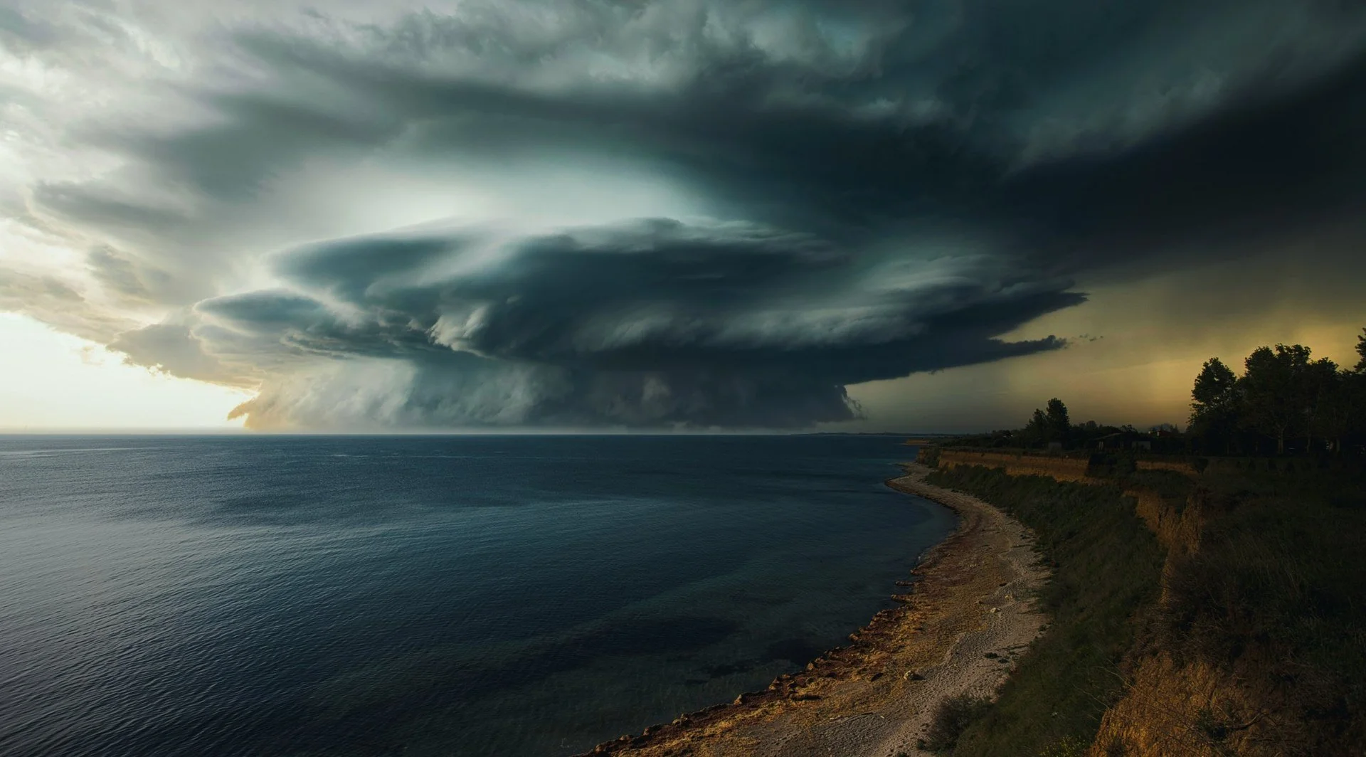 Dark storm clouds rolling in over the sea, illustrating the bear case and AI-bubble risks for the 2026 stock market.