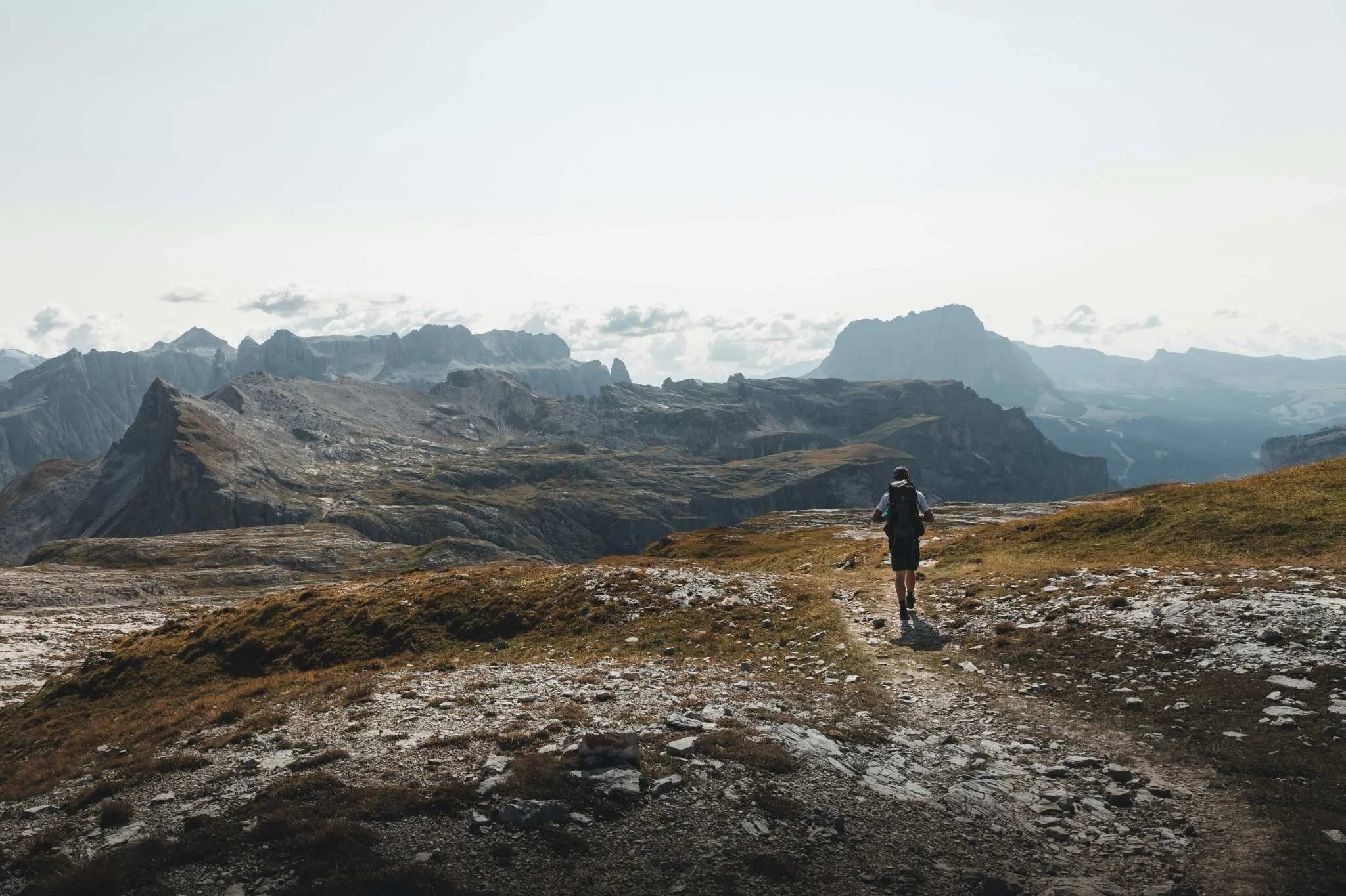 Man hiking through wilderness representing long-term life change and evolving goals.