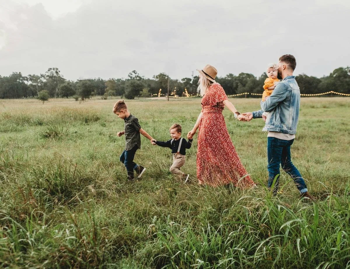 Family walking together through a field, representing financial independence and enjoying life without money stress.