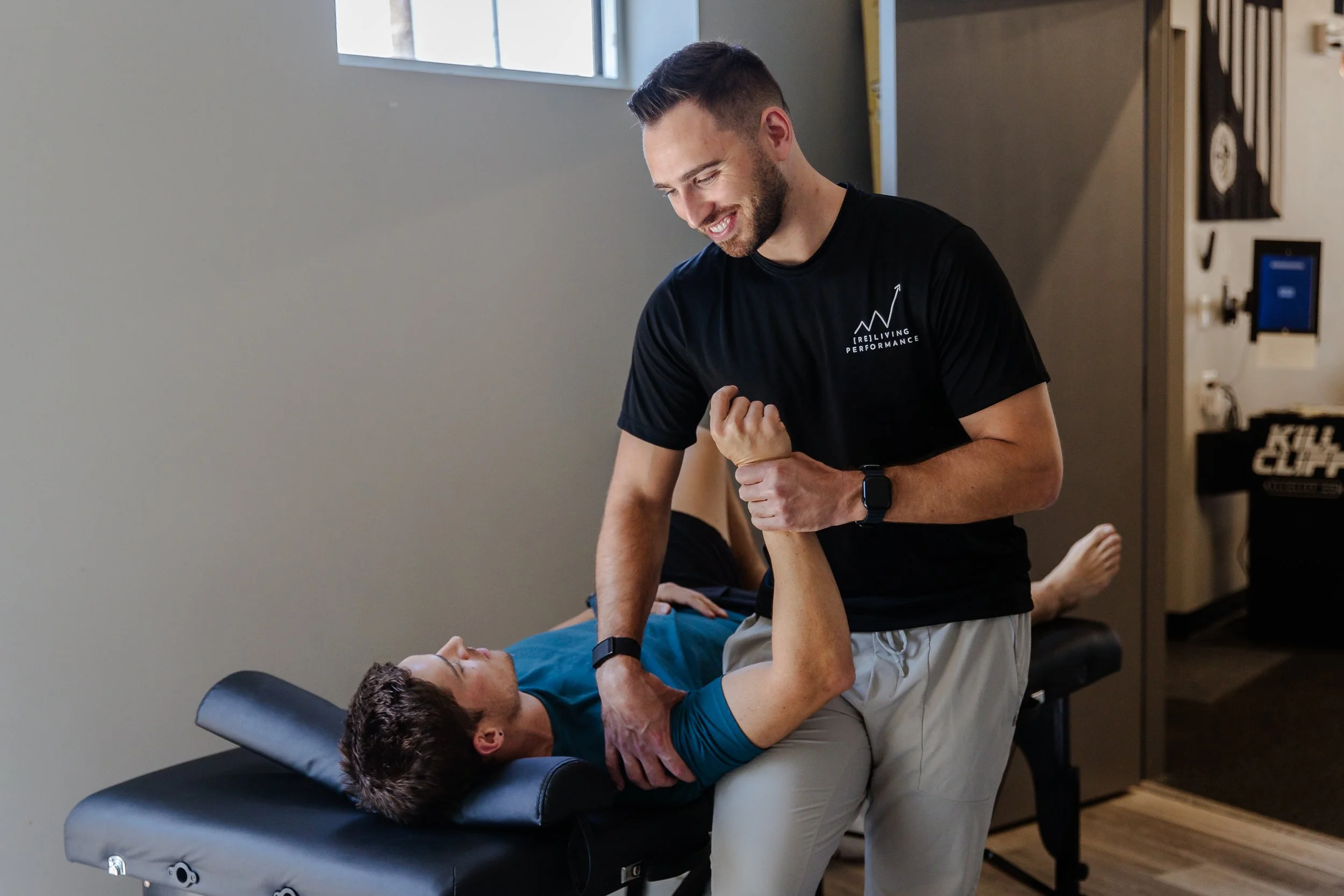 Physical therapist performing shoulder manual therapy and joint mobilization on patient at Reliving Performance in Greenville SC