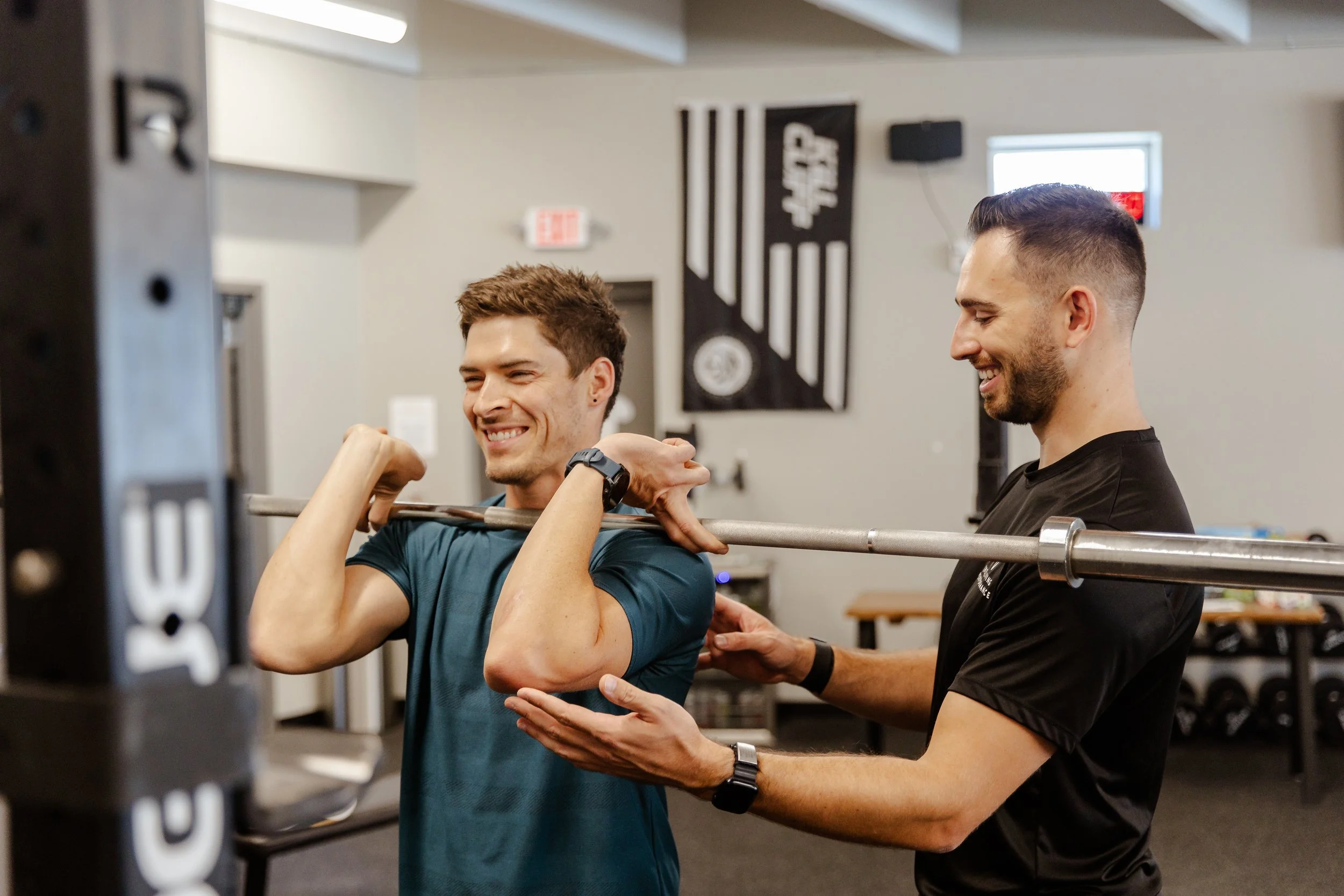 Board certified physical therapist coaching overhead barbell press for shoulder pain recovery at Greenville SC performance PT clinic