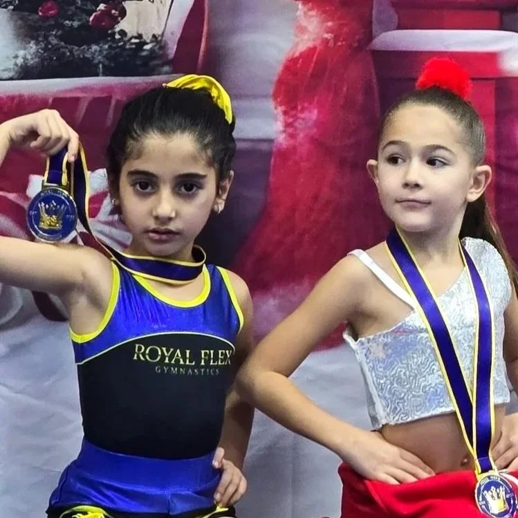 young girl holding royal flex gymnastics medal