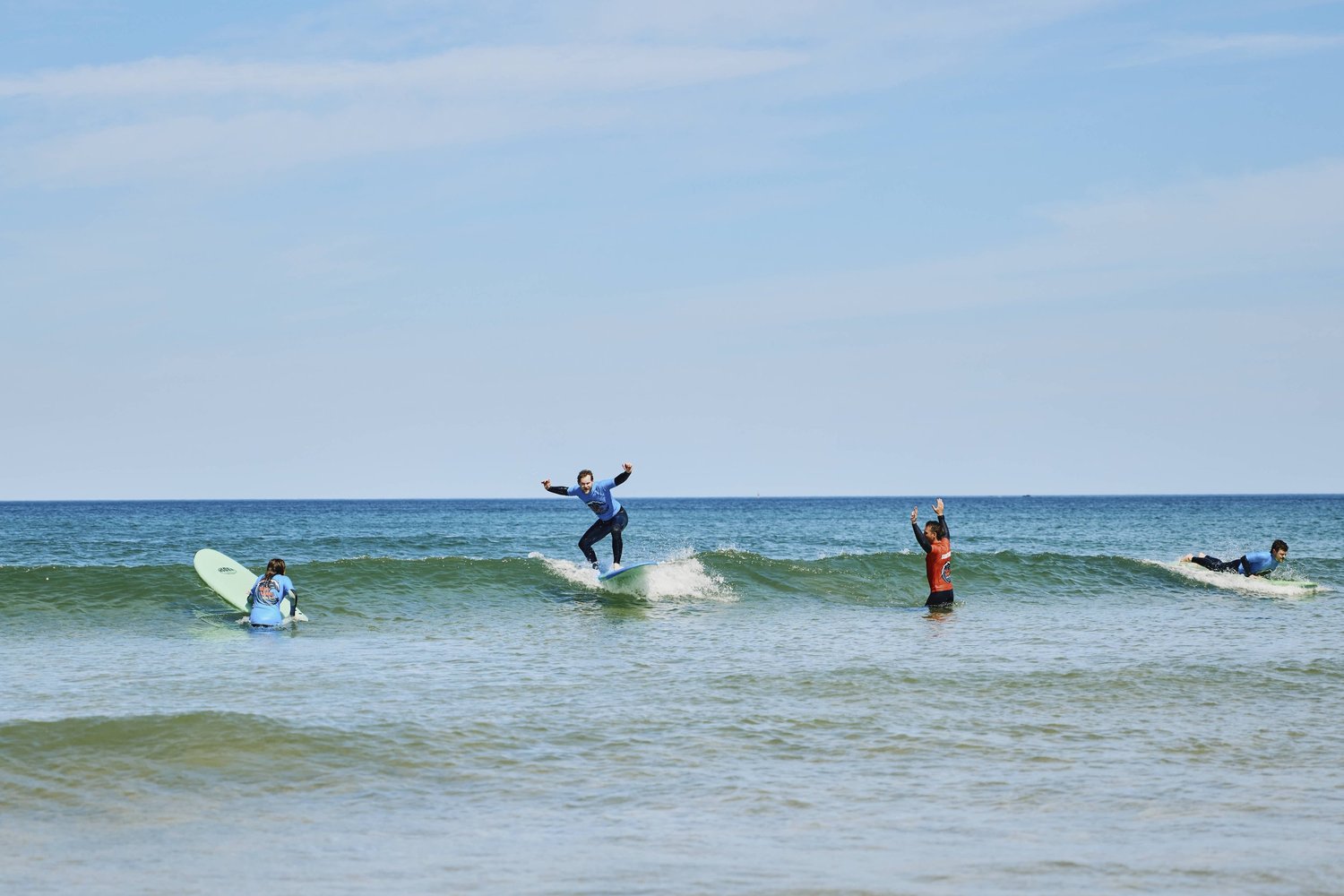 Surfers carrying surfboards on a Cornish beach before a surf lesson in Cornwall