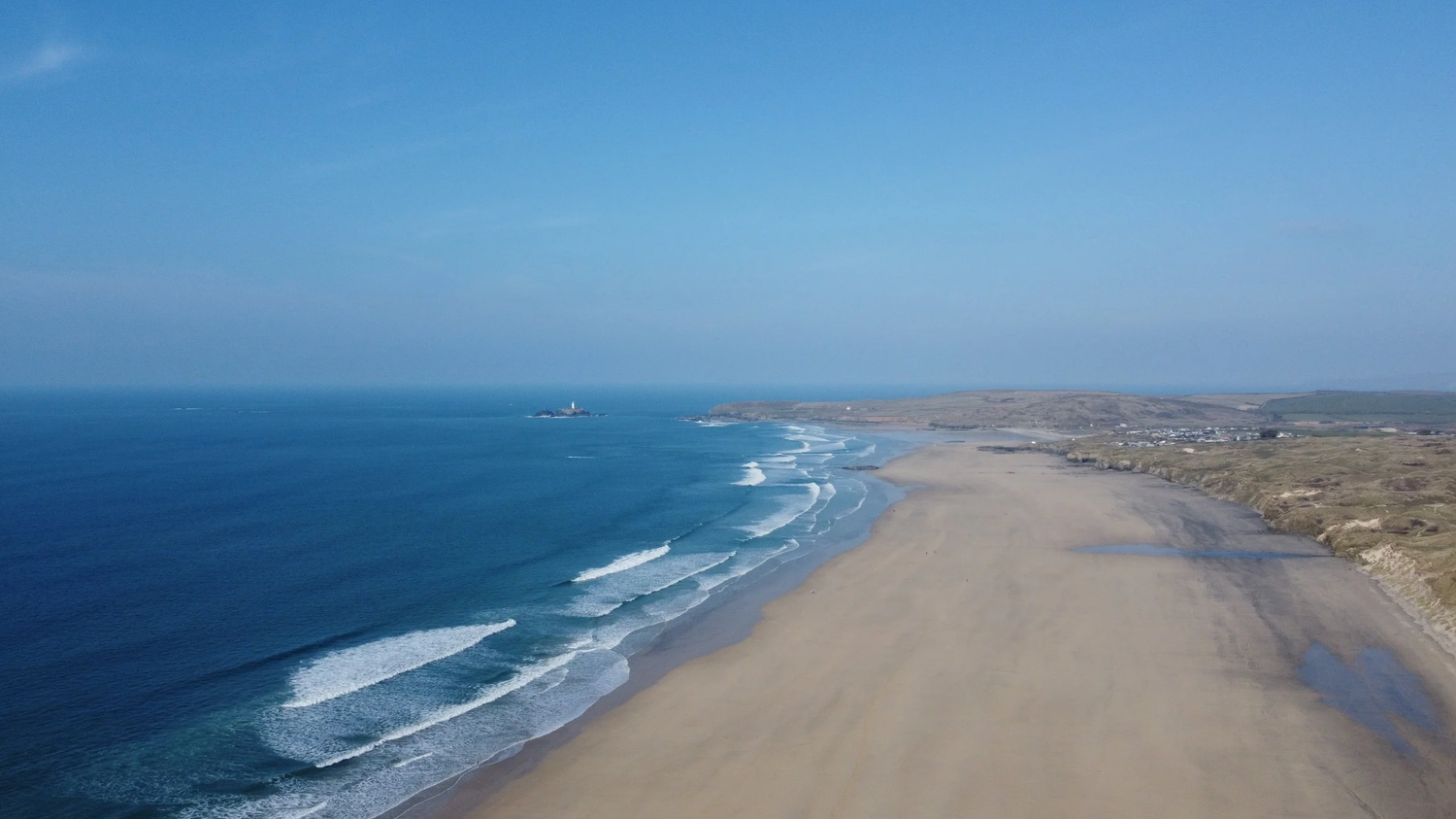 Aerial view of Gwithian beach at low tide looking towards Godrevy Lighthouse, St Ives Bay, Cornwall