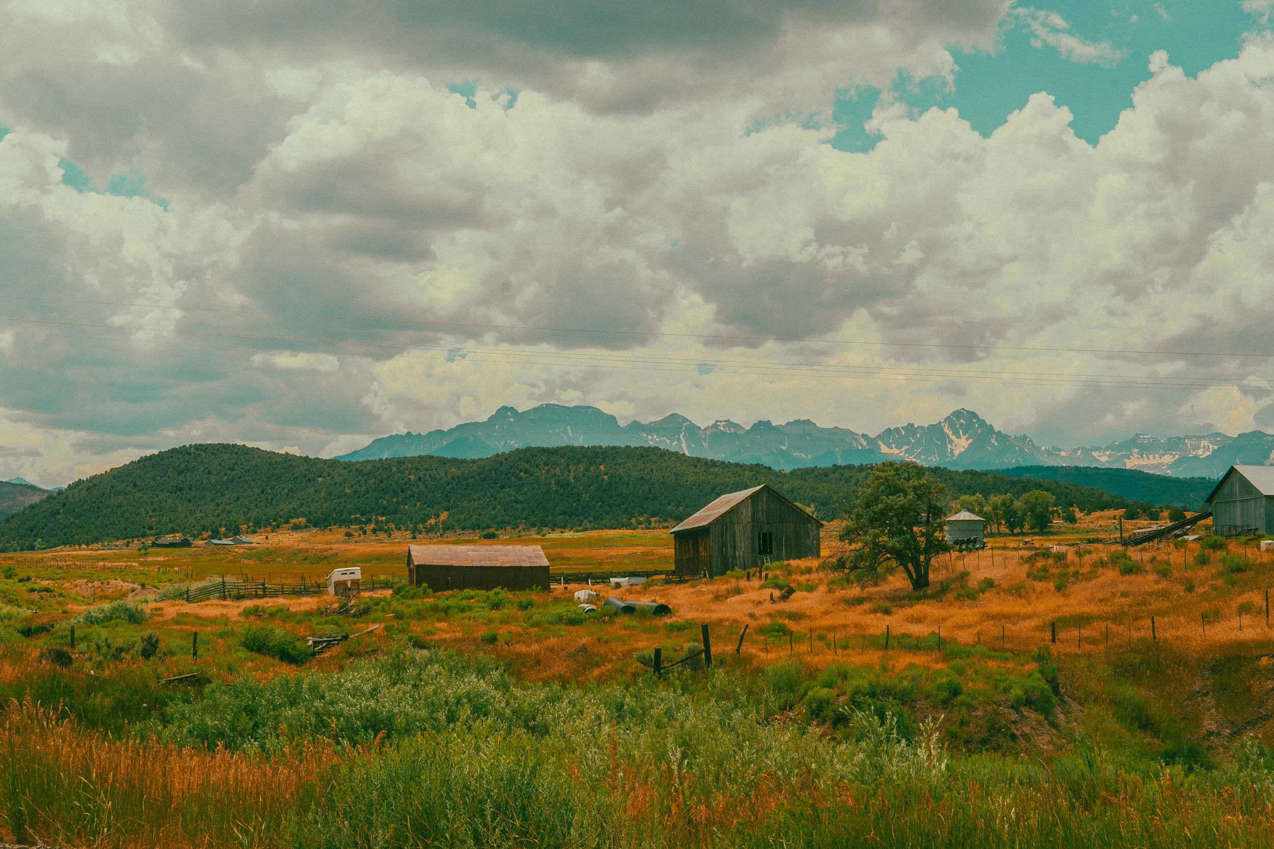 Rural landscape with barns, fields, and mountains
