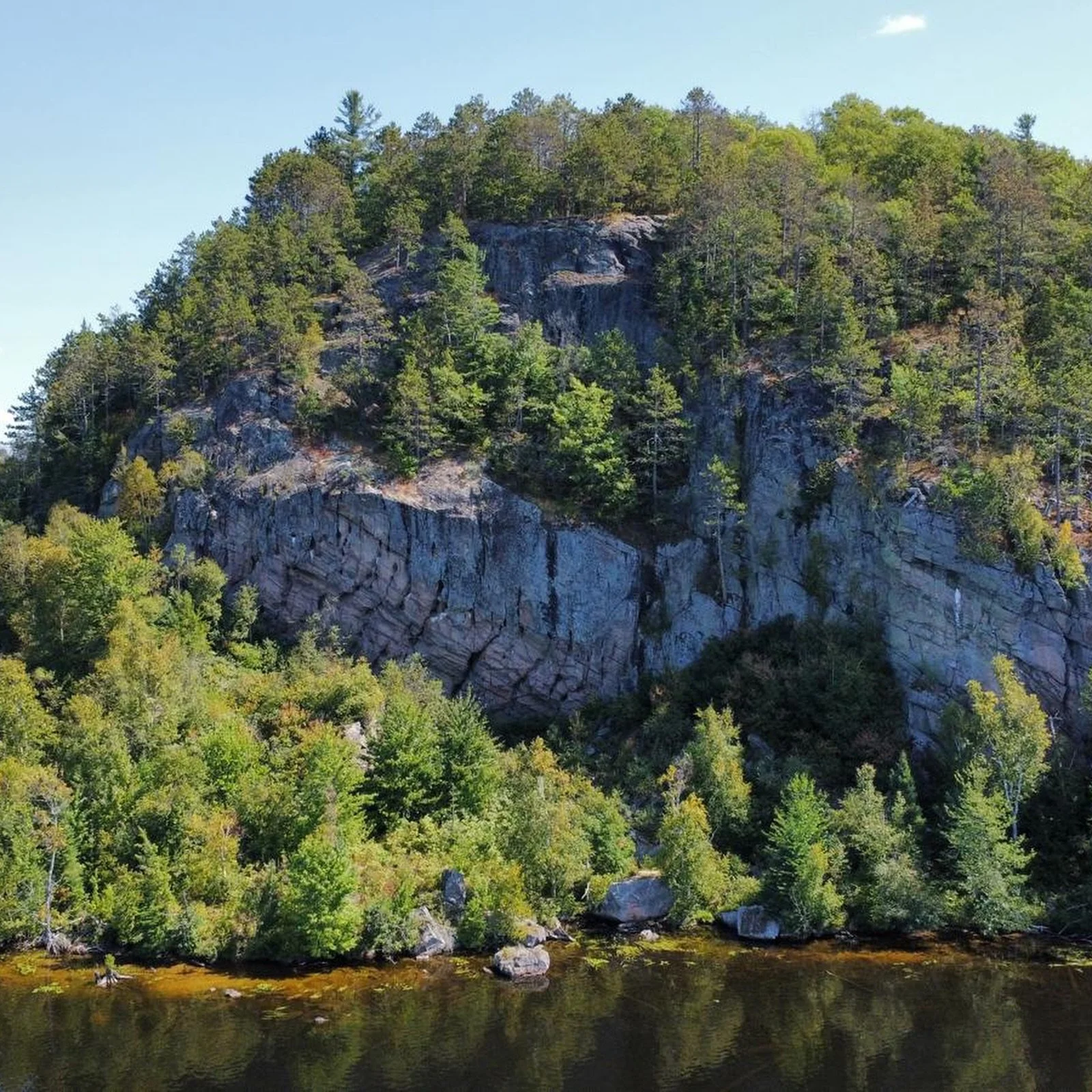 Blueberry Island&rsquo;s iconic cliff face. ⛰️
Towering granite cliffs, pine trees clinging to the rock face, and calm lake water below. The kind of place that reminds you how wild and beautiful Ontario cottage country really is.

You can paddle past