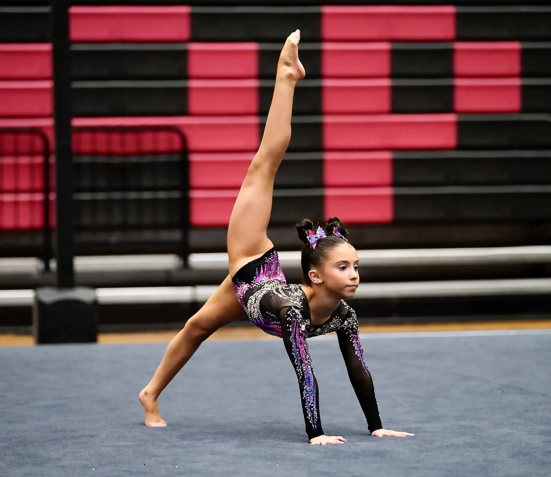 Female gymnast doing split pose on floor during competition