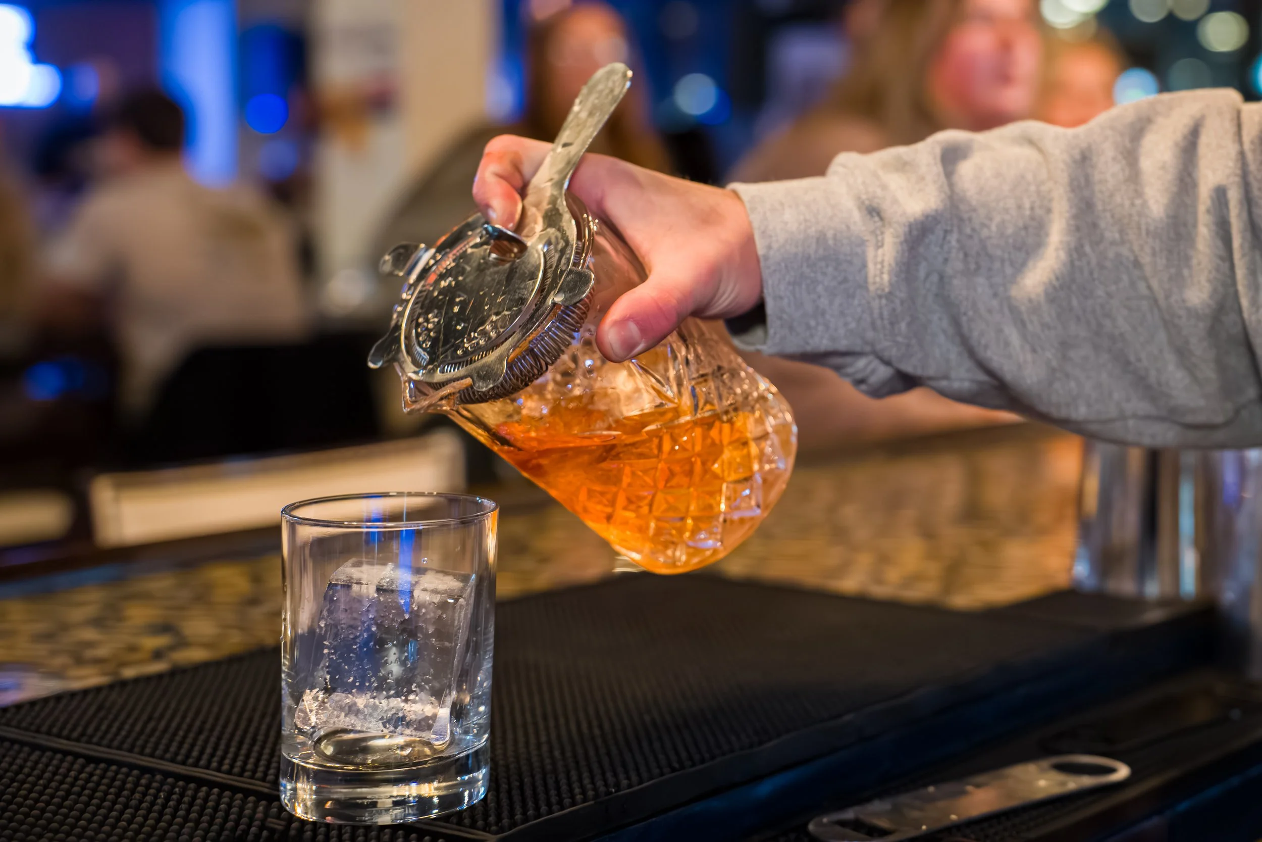Audience of diverse adults clapping and smiling at a formal event, with some military personnel in uniform standing at the back.