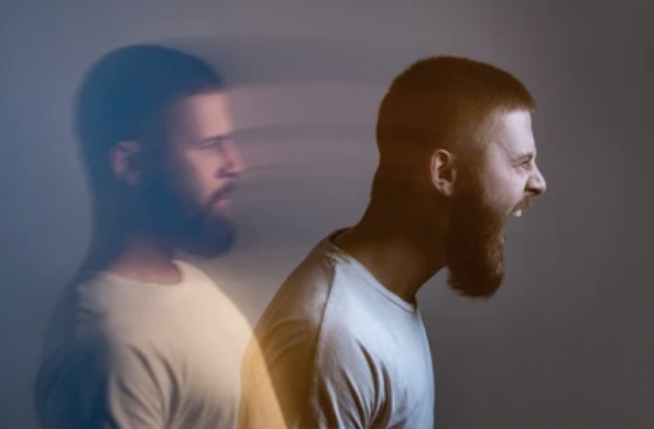 Bearded man standing and a second image of himself coming out of him as an angry yelling man.
