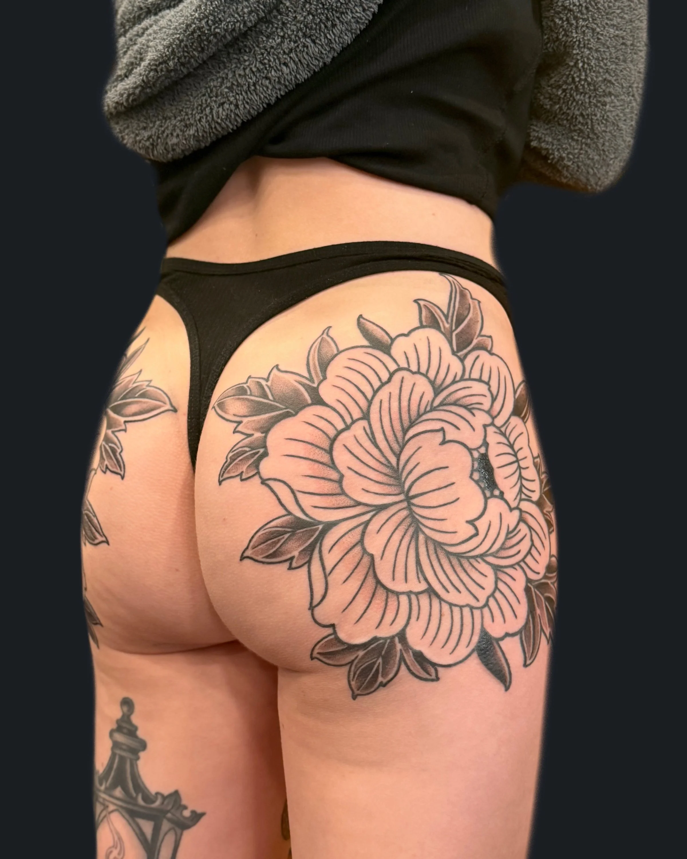 Blackwork ornamental symmetrical peonies on butt by English Cousins at Pilgrimage Tattoo in Nashville, TN.