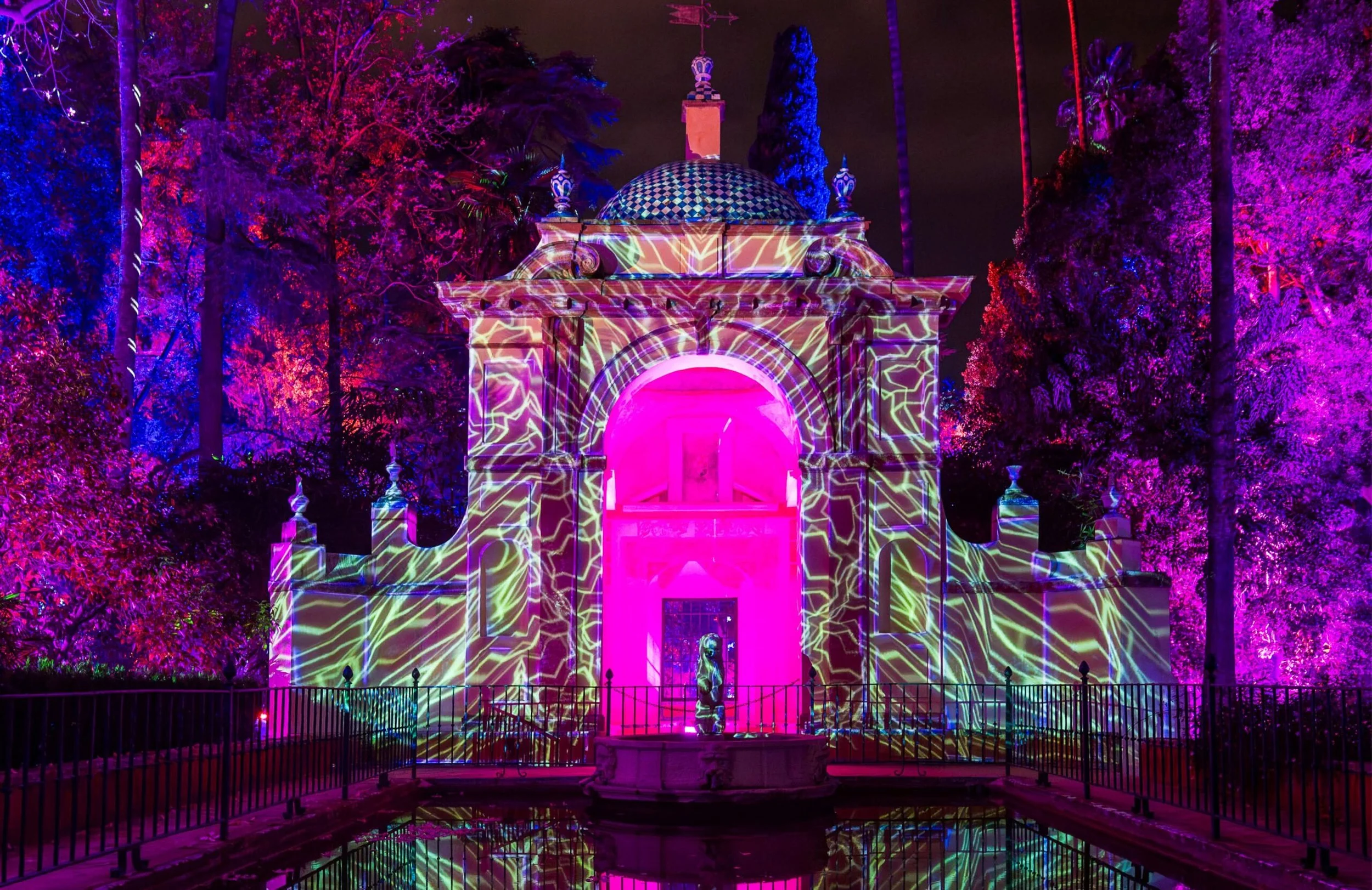 Instalación luminosa de Naturaleza Encendida en el Real Alcázar de Sevilla durante la Navidad 2025, con proyecciones artísticas sobre arquitectura histórica.