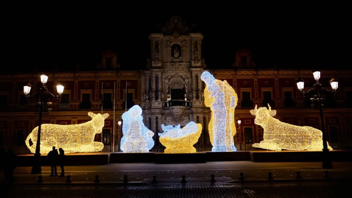 Misterio luminoso de Navidad en Sevilla frente al Palacio de San Telmo, con figuras gigantes iluminadas de la Sagrada Familia, buey y mula.