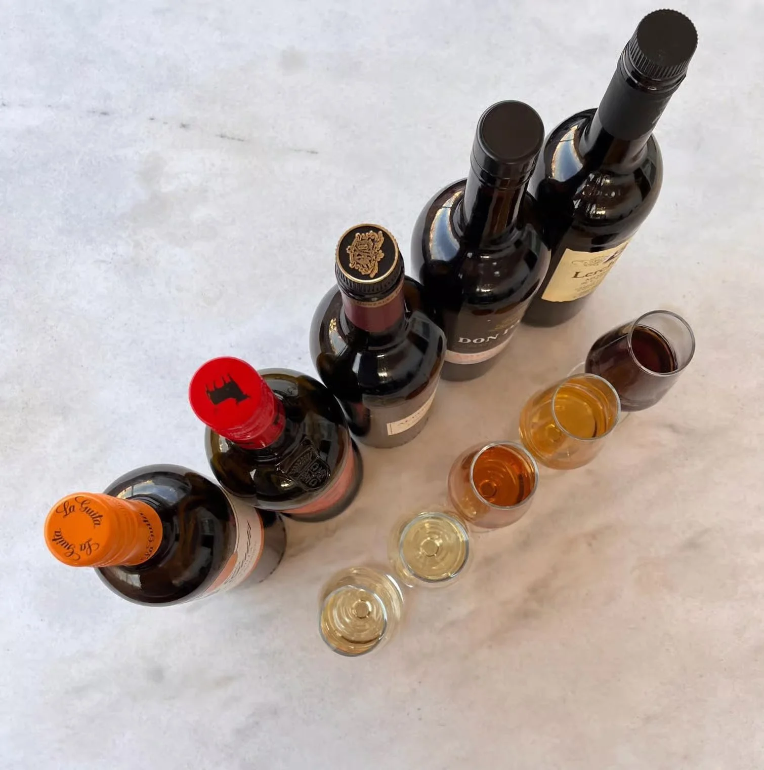 Botellas y copas de vinos de Jerez dispuestas para una cata en Sevilla, mostrando diferentes variedades andaluzas listas para degustar con aperitivos.