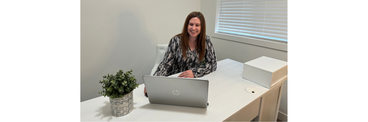 Lindsay Fuchs sitting at a desk emailing