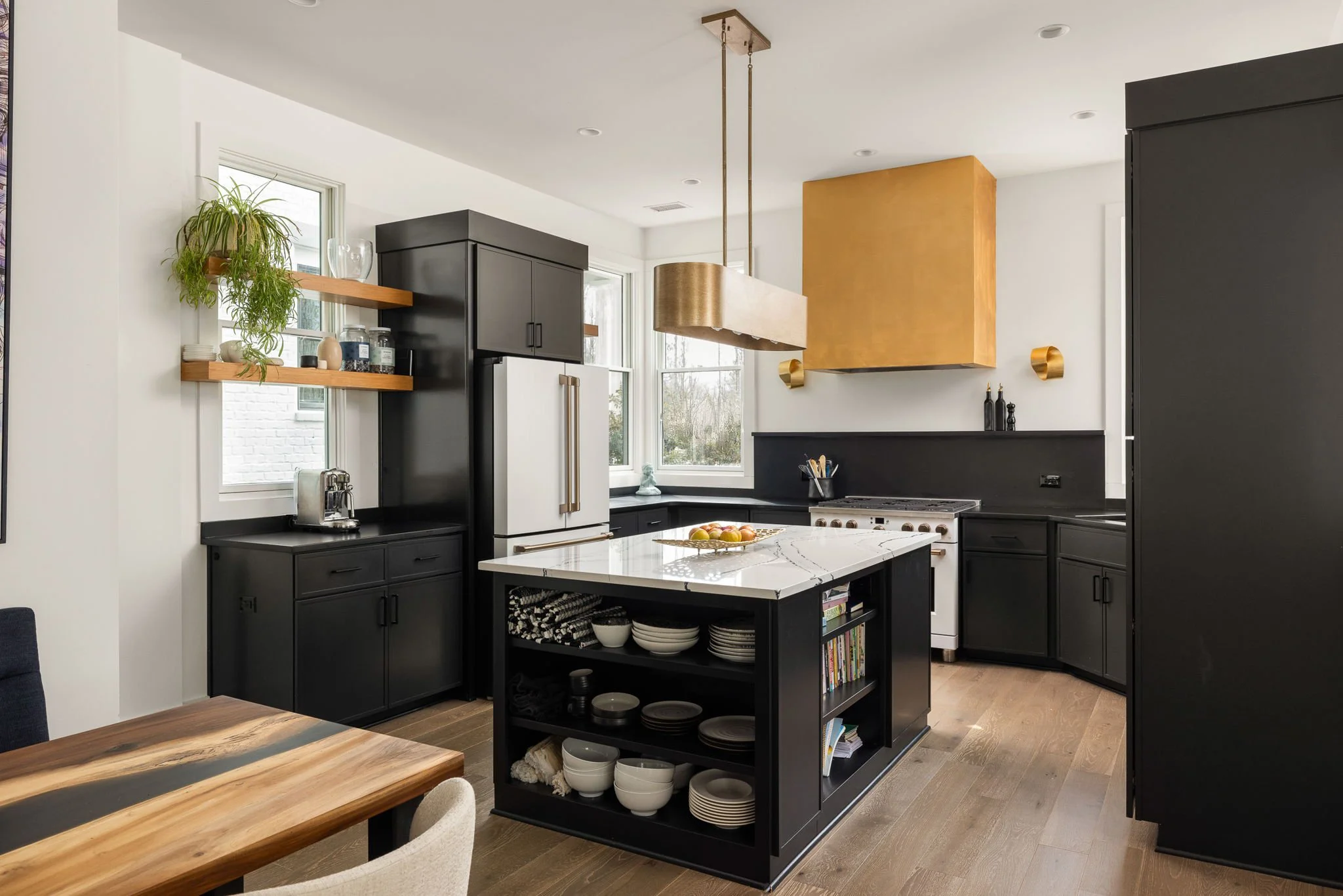 Modern kitchen with black cabinetry and brass fixtures.