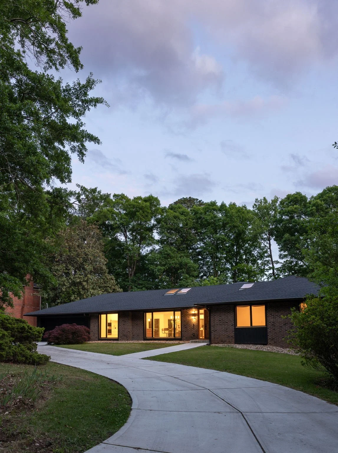 An exterior image of a midcentury modern home in north Atlanta, photographed at dusk.