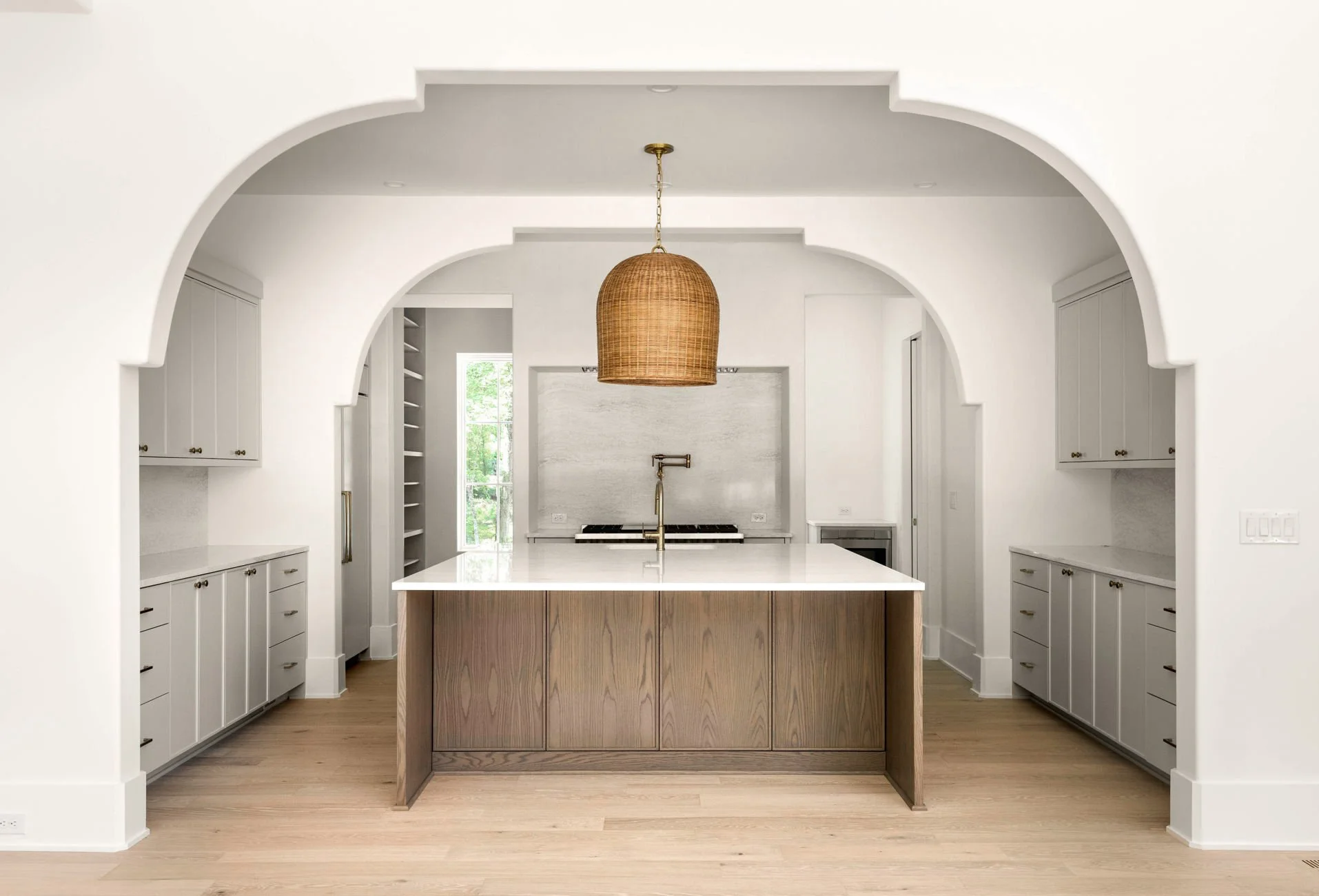 Symmetrical white kitchen with large pendant light