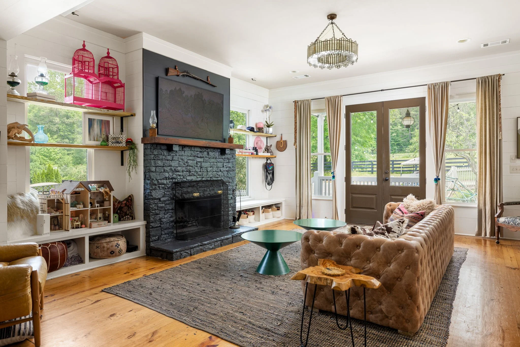 Colorful furniture blends with a dark fireplace in this bright naturally lit living room.