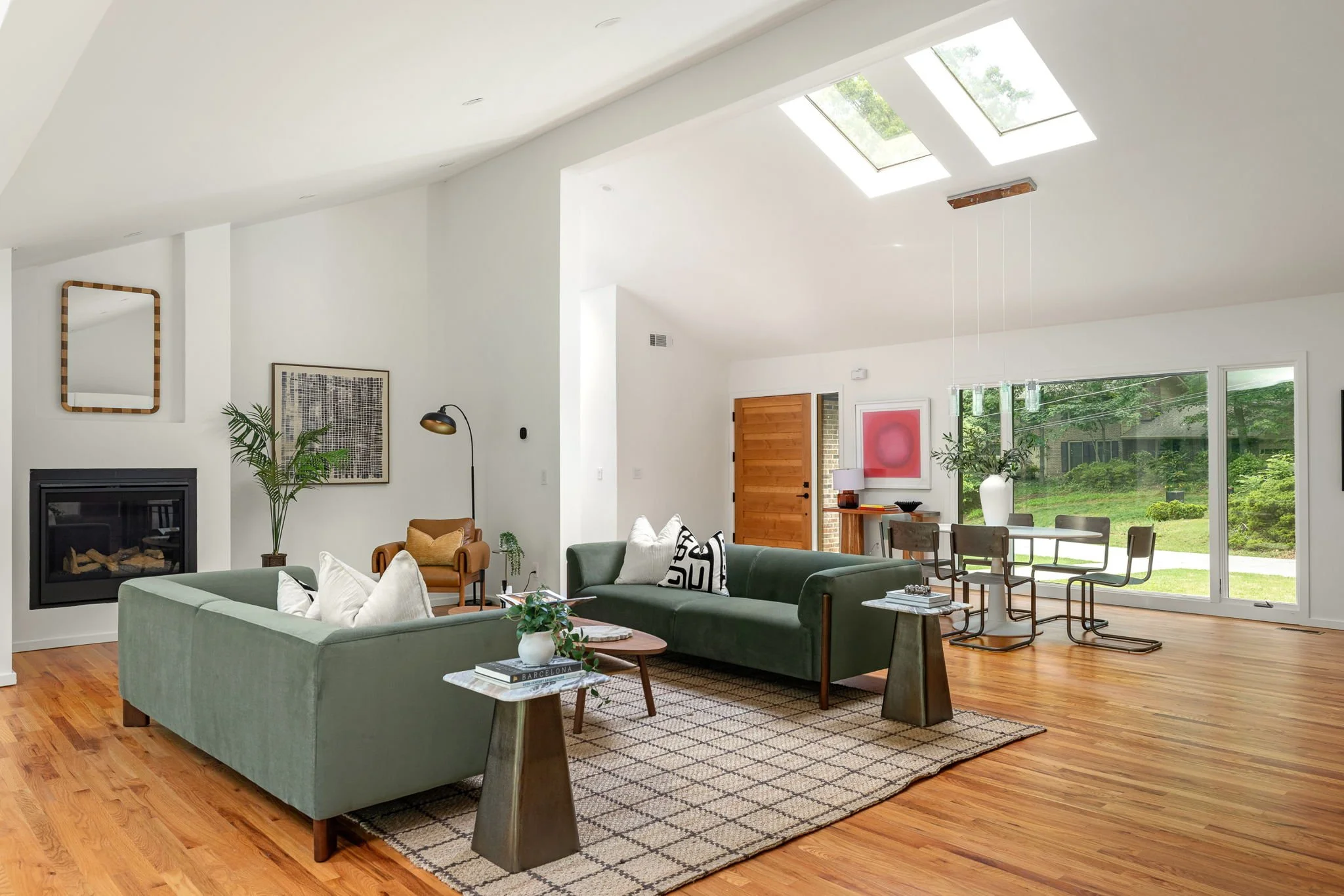 A modernly furnished living room with skylights and an inset fireplace.