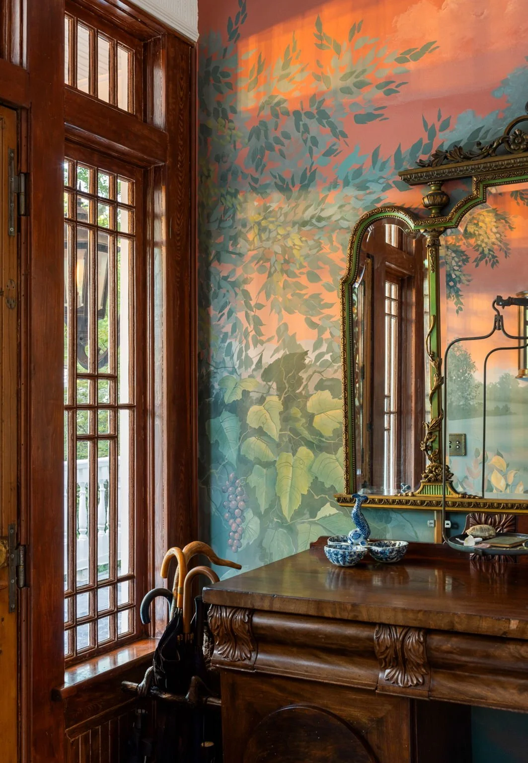 Hand painted walls compliment antique furniture and a wooden door imported from Versailles.