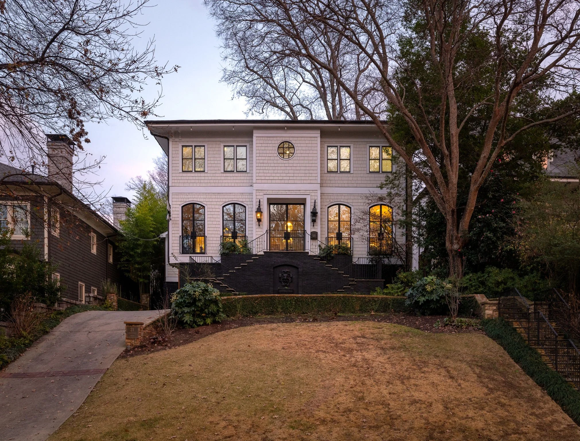 A historic home sits atop a hill in Ansley Park, Atlanta, photographed at dusk.