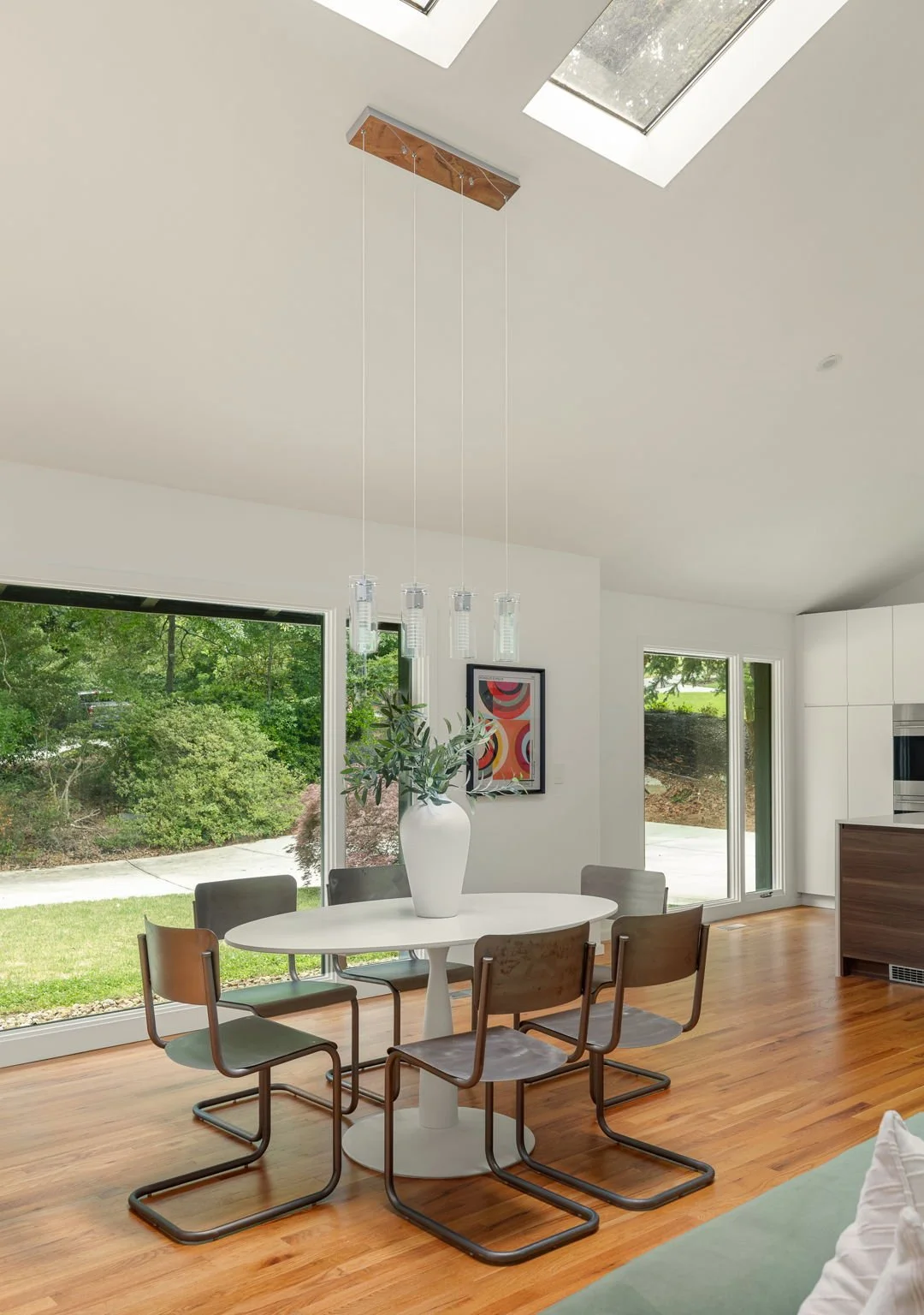 Large windows and skylights illuminate this dining area in a modern home.