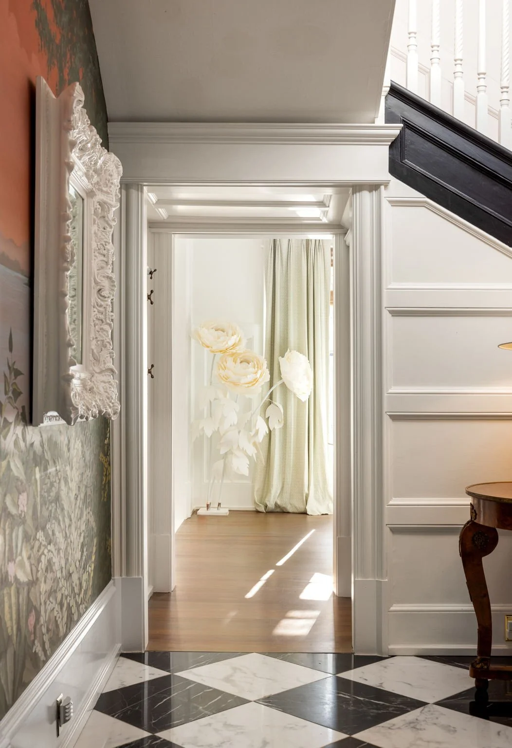 A unique sculpture viewed through the doorway of an historic staircase.