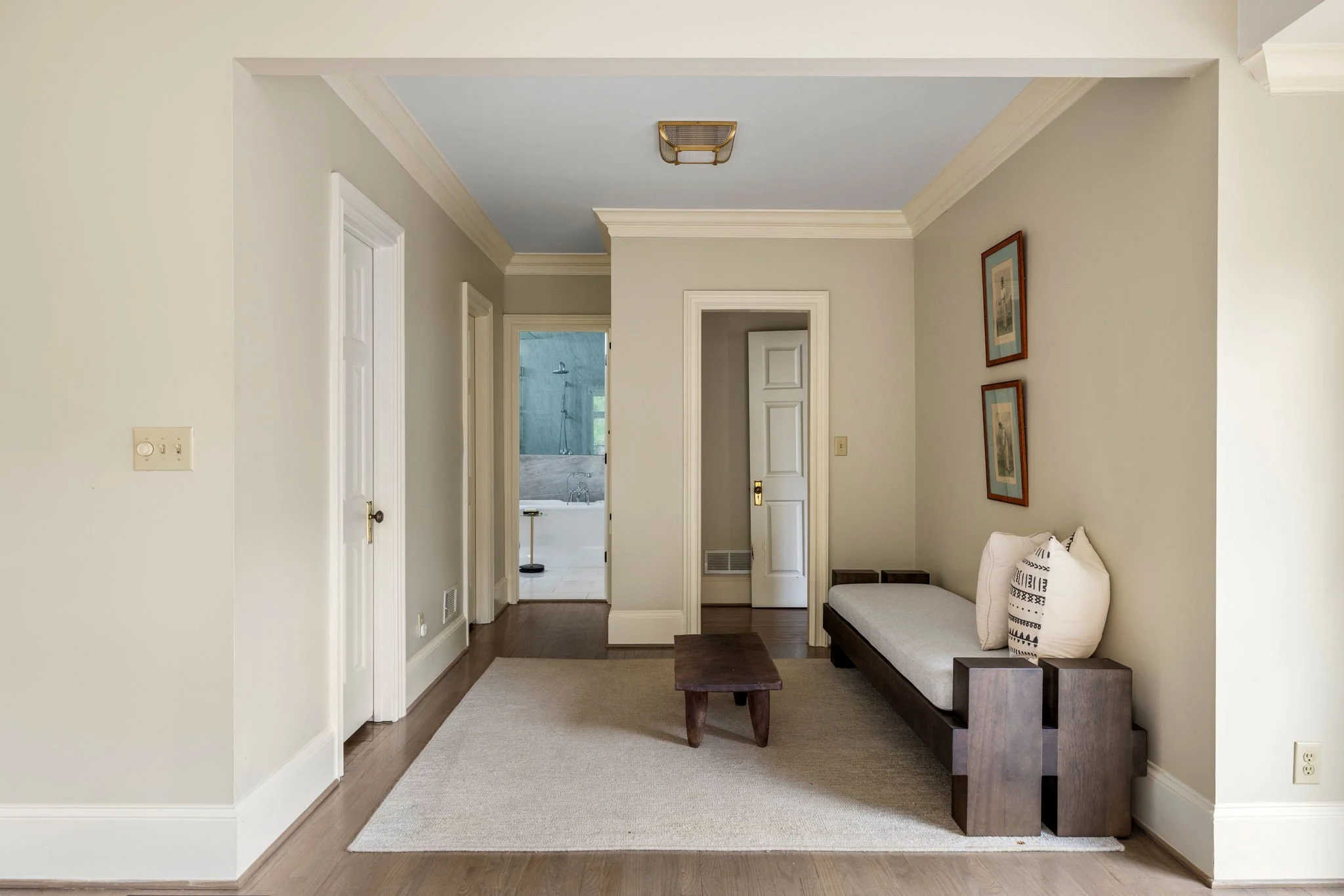 A moody transitional room in a primary suite that leads to the primary bathroom.