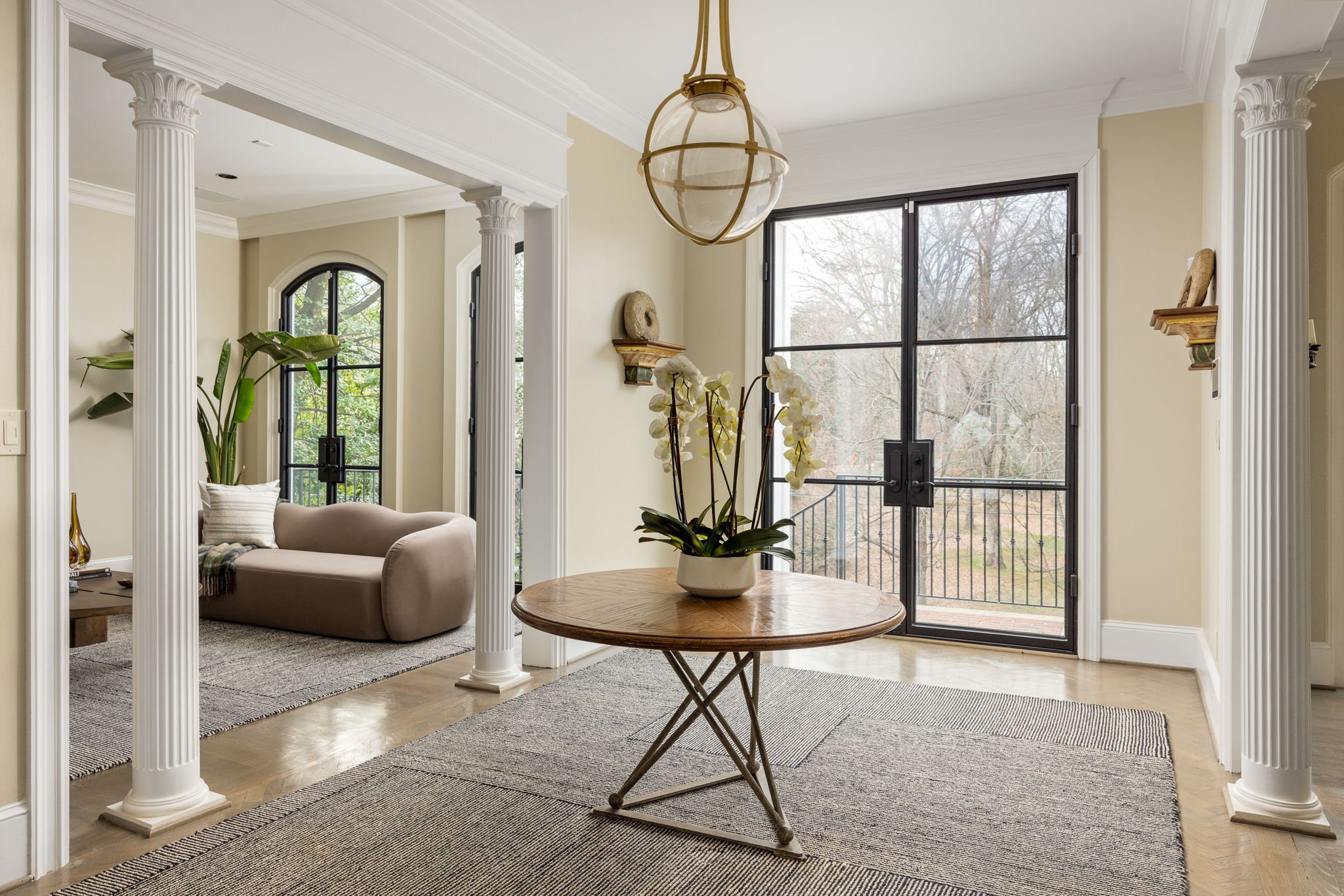 The entryway to this historic house features columns and steel glass doors.