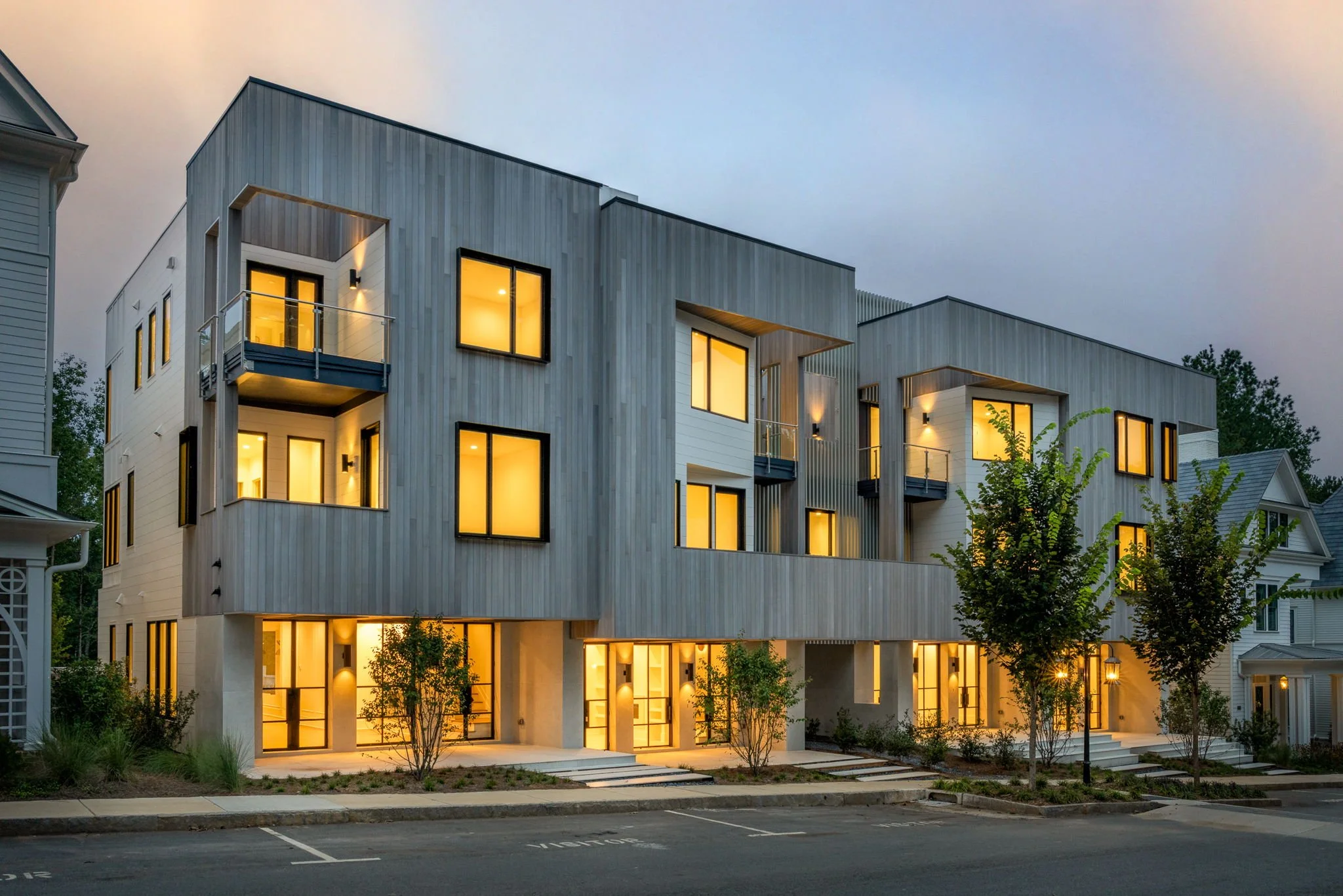 Modern townhouses with new building materials photographed at dusk.