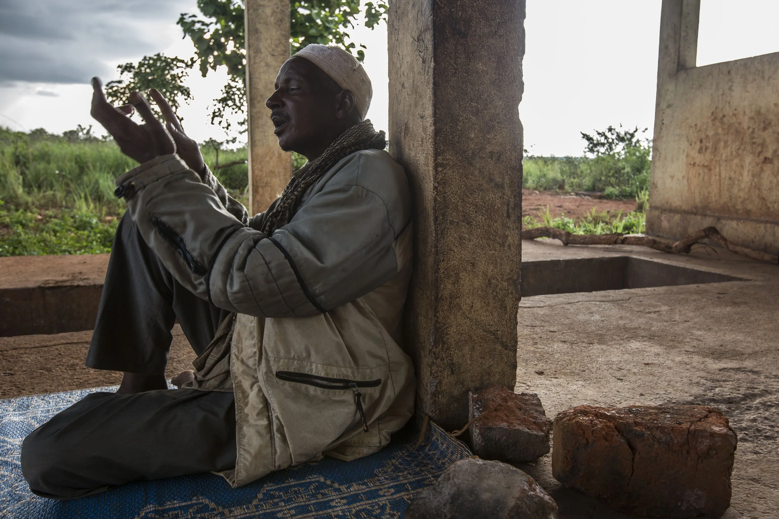 Moussa praying for resolution as he narrates the plight of his family and the loss of his 800 cows. He had lost both of his parents on the site due to dire living conditions and one of his children due to malnutrition.