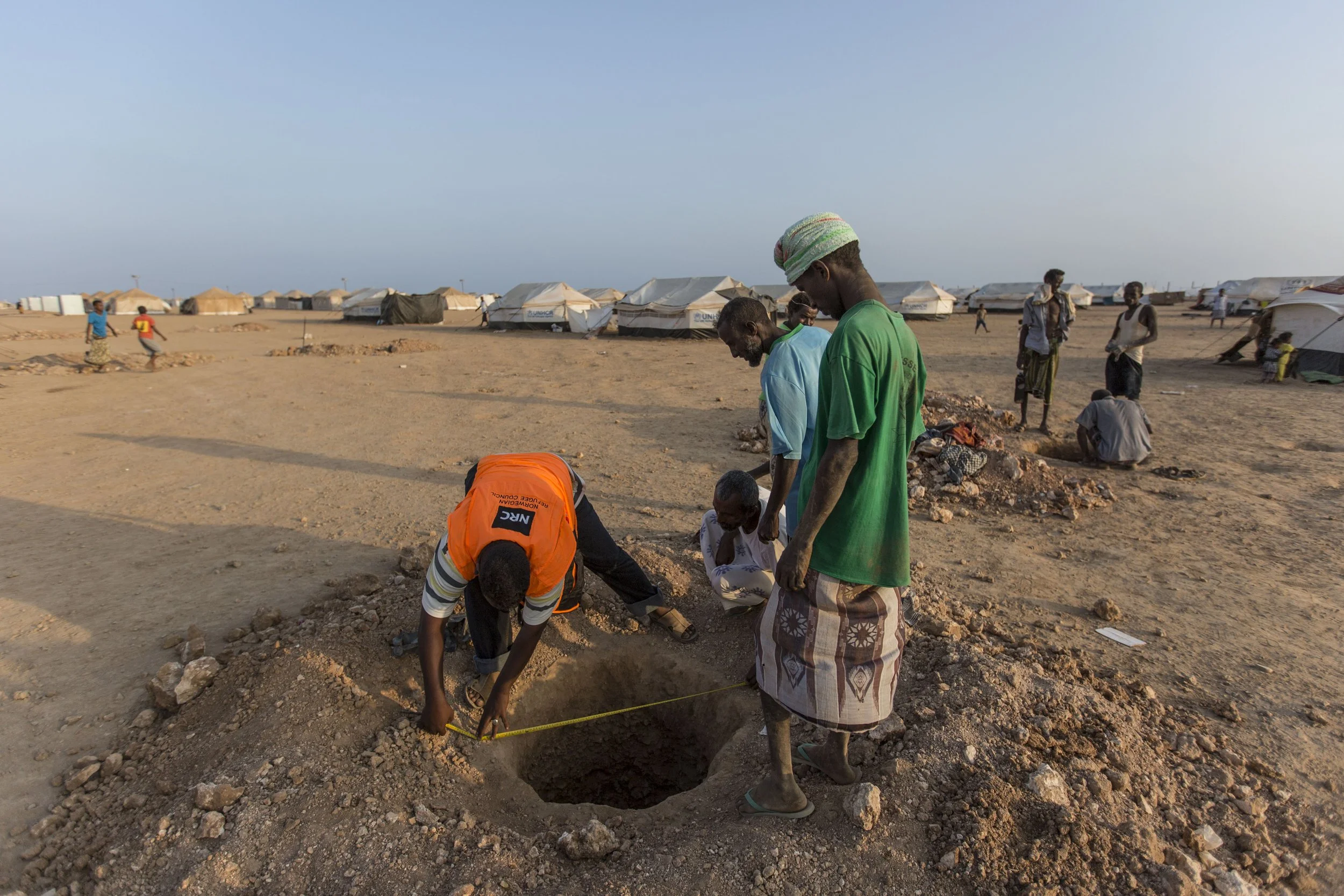 Yemeni refugees work with humanitarian organisations to build latrines around the camp. As the refugee population expands, the need to develop more services becomes urgent, warn aid agencies.