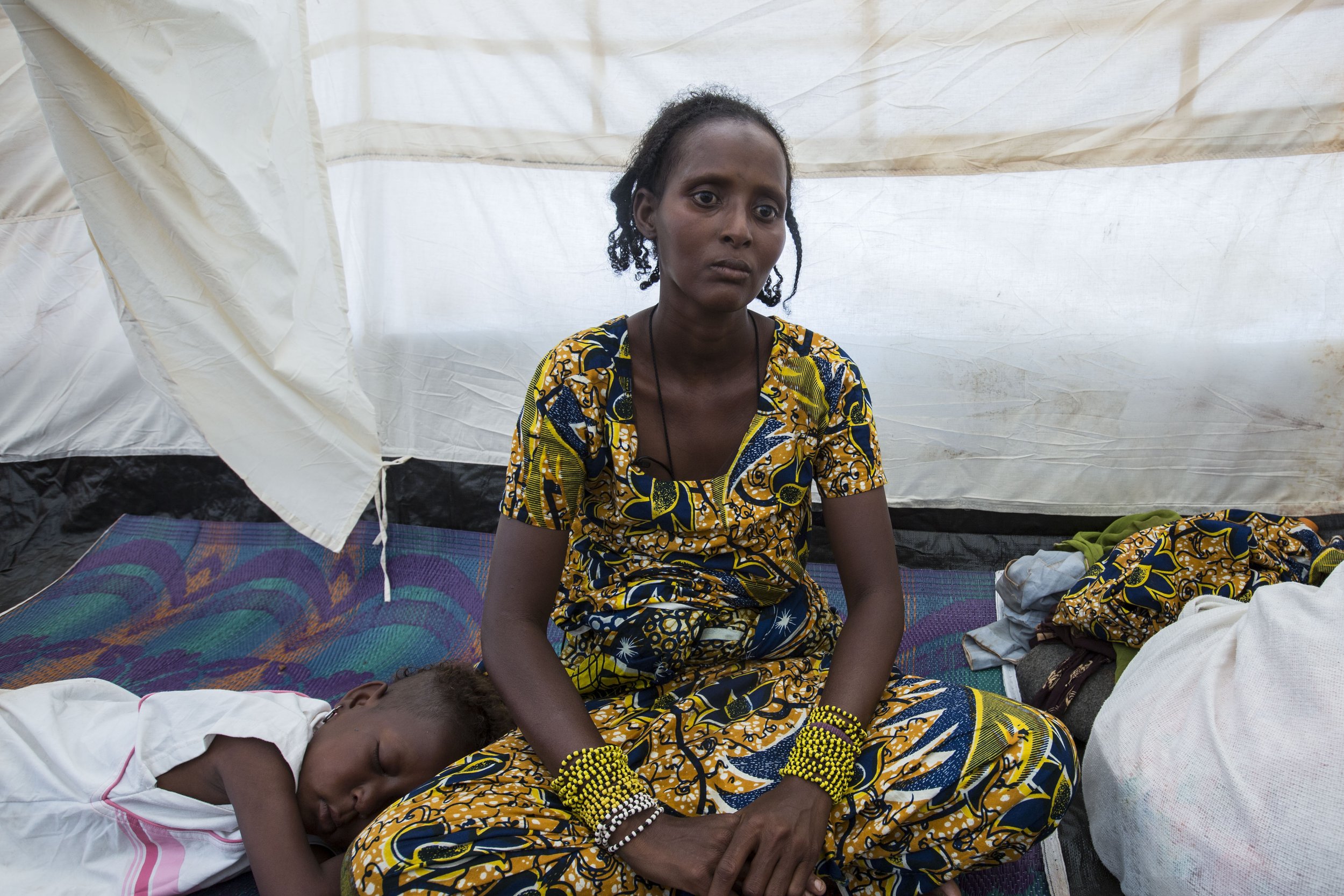 Having just lost her daughter Rachida, Halima sits for the first time in her new tent as a refugee in Cameroon. She was evacuated following escalation through the mission's findings. Surviving Awa, who also suffers from malnutrition, has been feeling