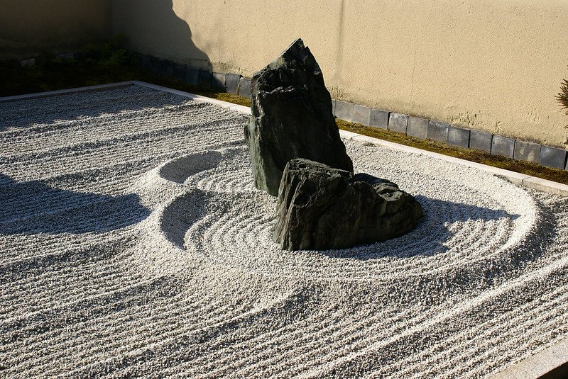 The dry garden in Nanzenji, Kyoto, featuring carefully arranged rocks and gravel in minimalist patterns, reflecting Zen principles and creating a peaceful, meditative atmosphere.