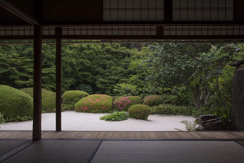 A serene garden at Daitoku-ji Temple in Kyoto, featuring minimalist design, carefully placed stones, and lush greenery, embodying the principles of Zen garden aesthetics.