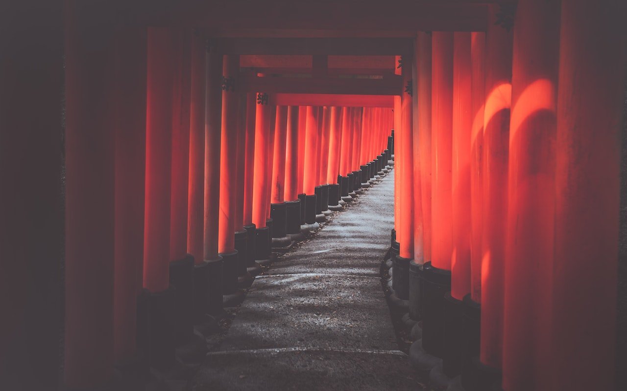 Pathway of vibrant red torii gates at Fushimi Inari Shrine in Kyoto.