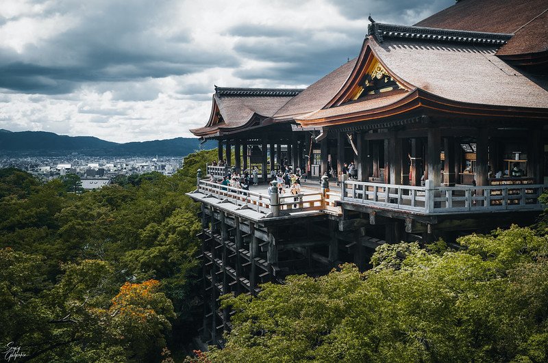 Main deck at Kiyomizu Temple offering panoramic views of Kyoto's cityscape and surrounding nature.