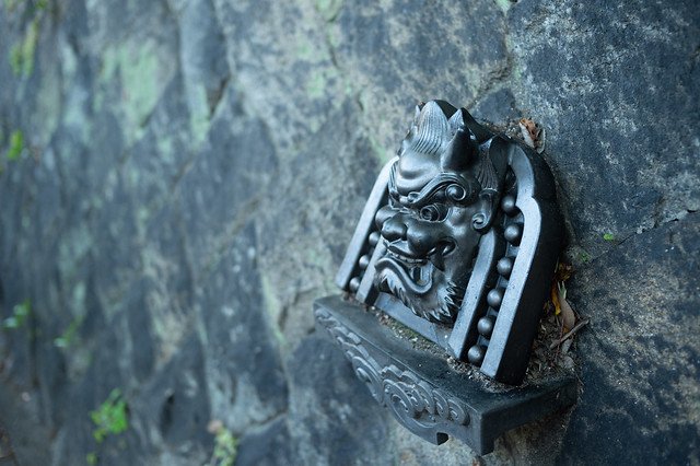 A ceramic gargoyle on a traditional Kyoto roof, showcasing intricate craftsmanship and adding a unique touch to the architectural design.