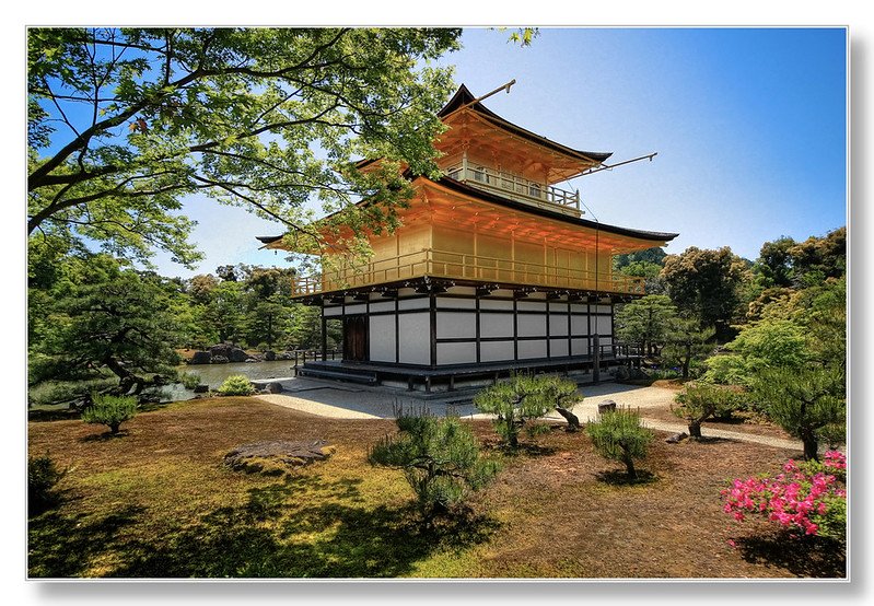 The Golden Pavilion (Kinkaku-ji) in Kyoto, Japan, showcasing its stunning golden exterior reflecting in the tranquil pond surrounded by lush greenery.