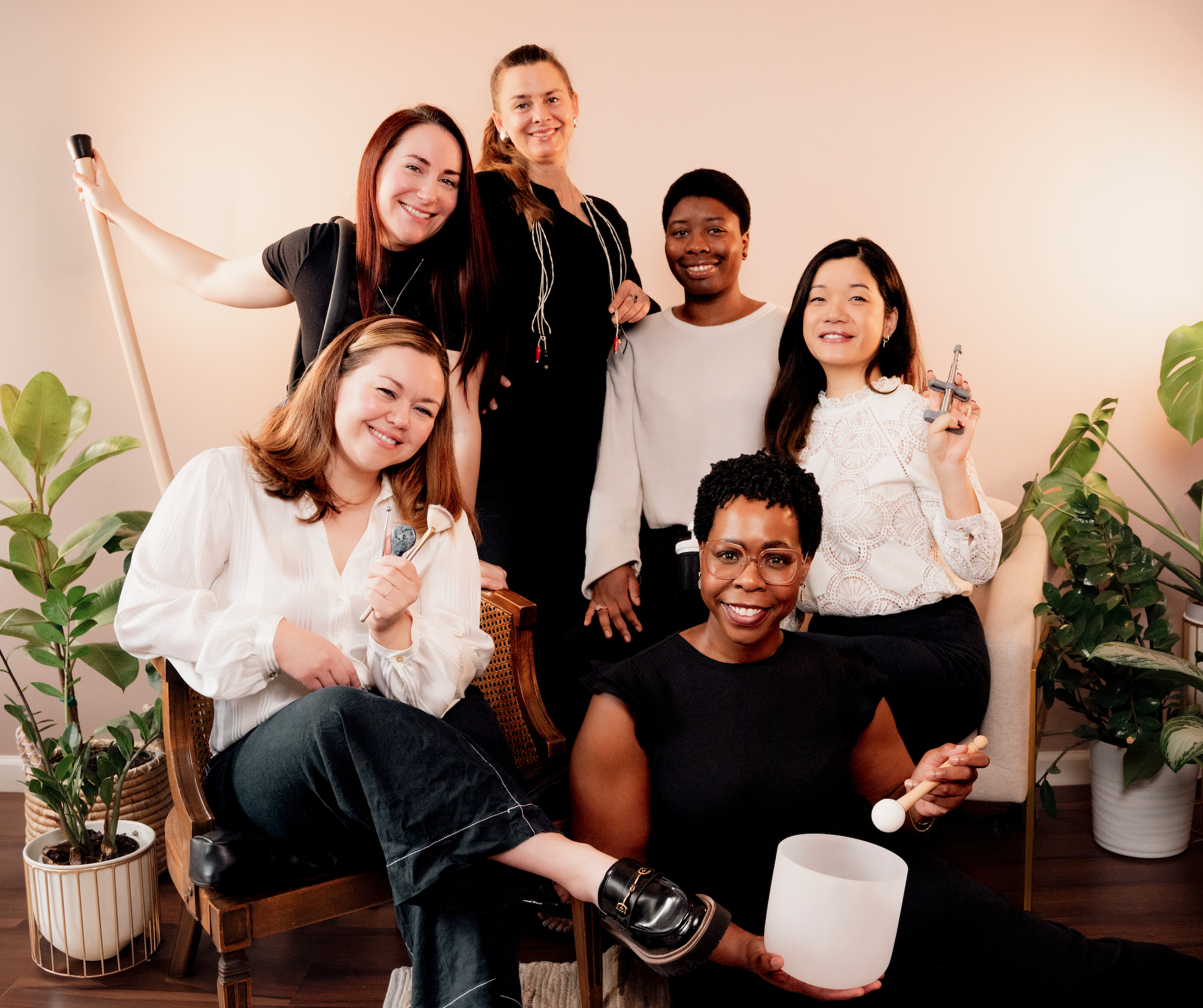 The collective of independent wellness practitioners at Bliss Studio ATX posing together in their Austin sanctuary.