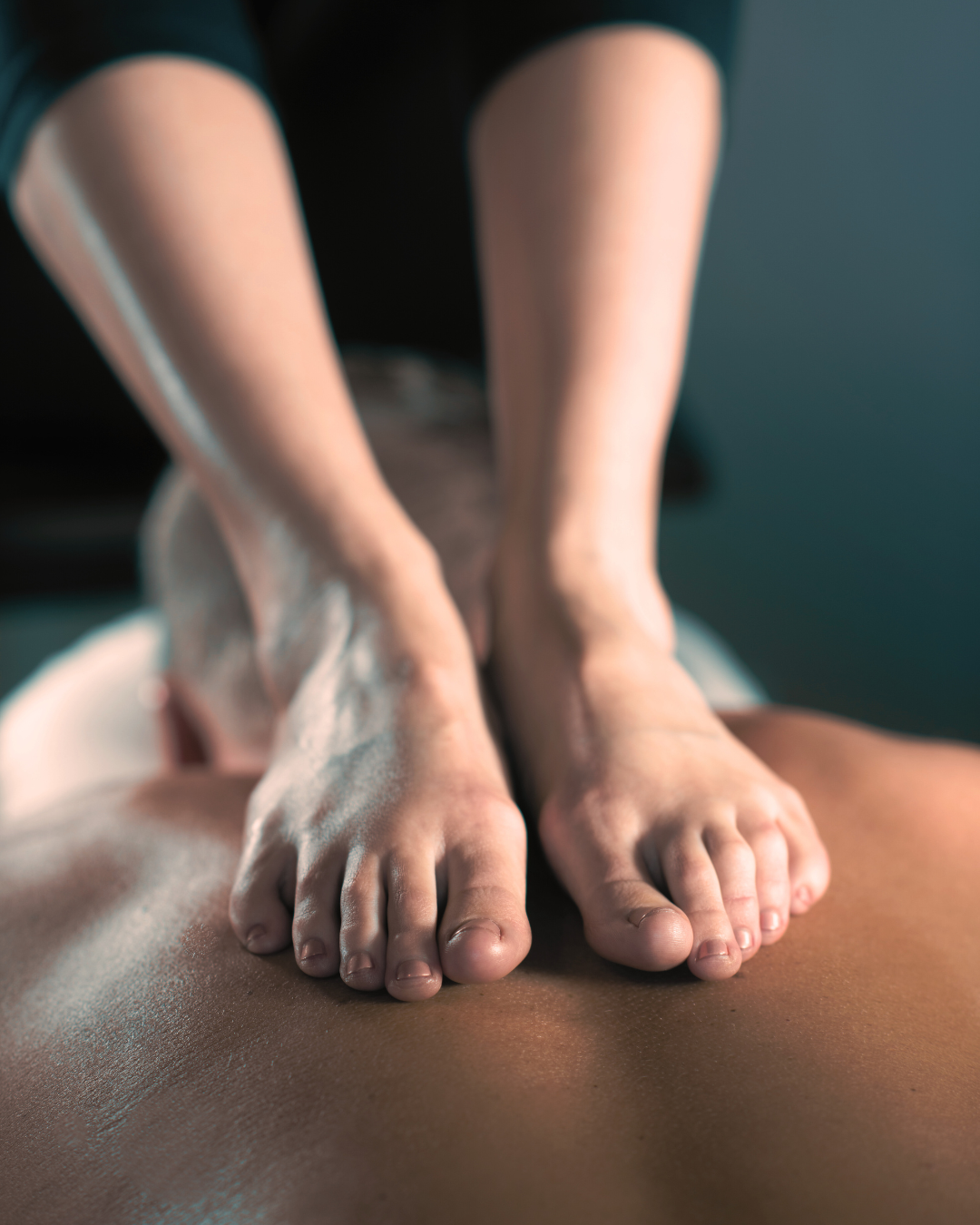 Ashiatsu barefoot massage technique where the therapist uses feet for consistent, deep compression on the back.
