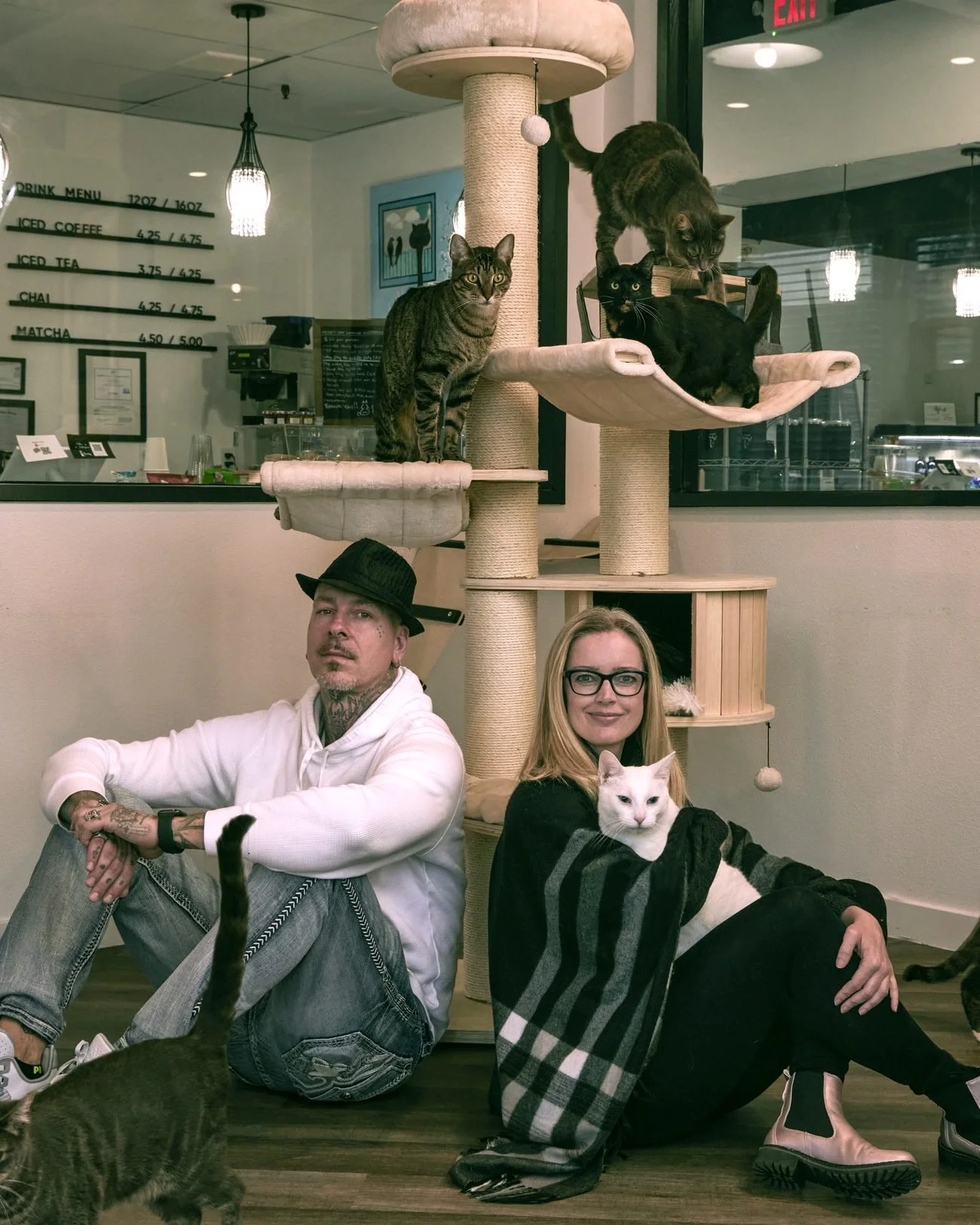 Claire and Sonny Von Cleveland sitting among the cats at Frisky Business Palm Springs Cat Café