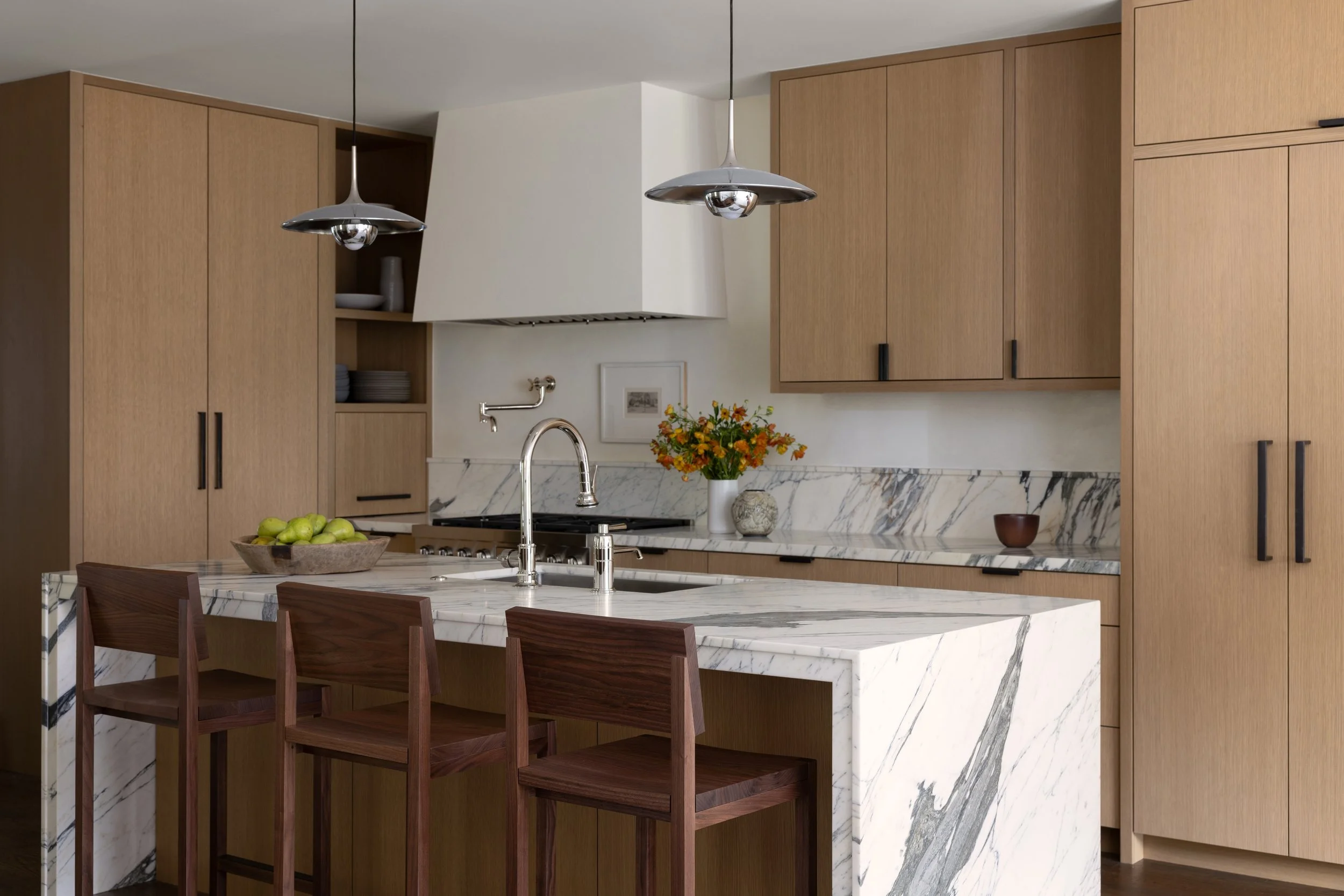 View of the kitchen with kitchen island and stools.
