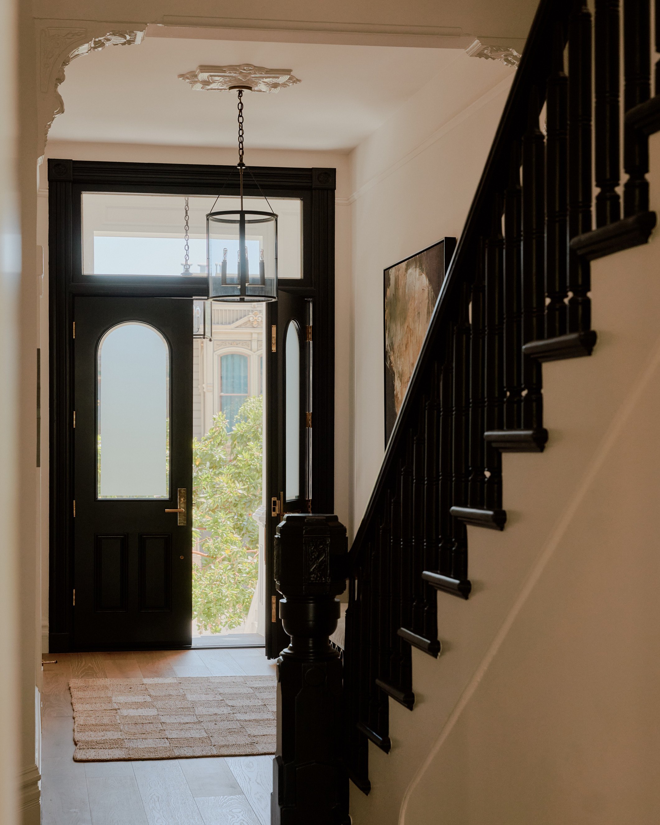 Entryway and staircase with open front door.