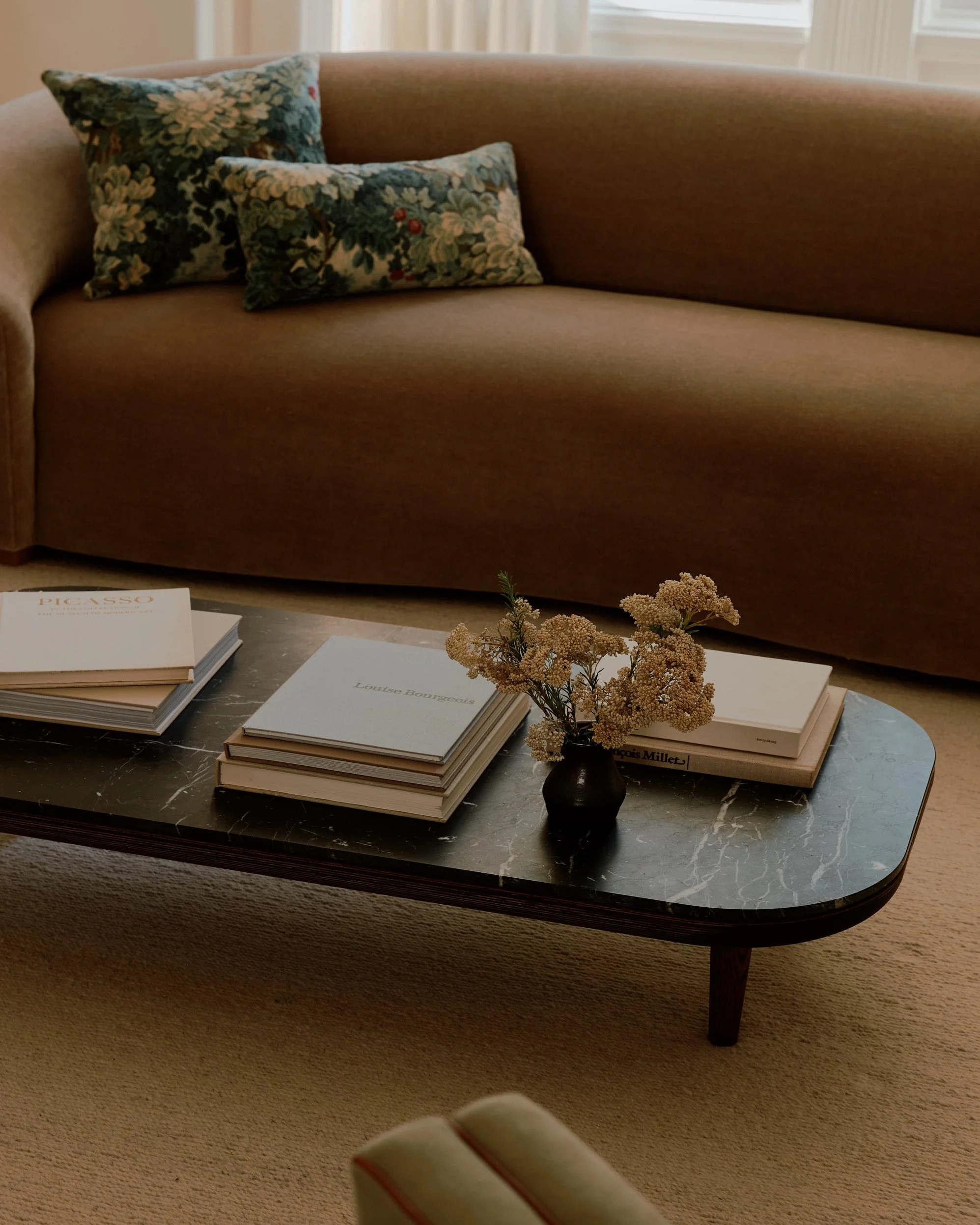 Coffee table and sofa detail with books and decor.