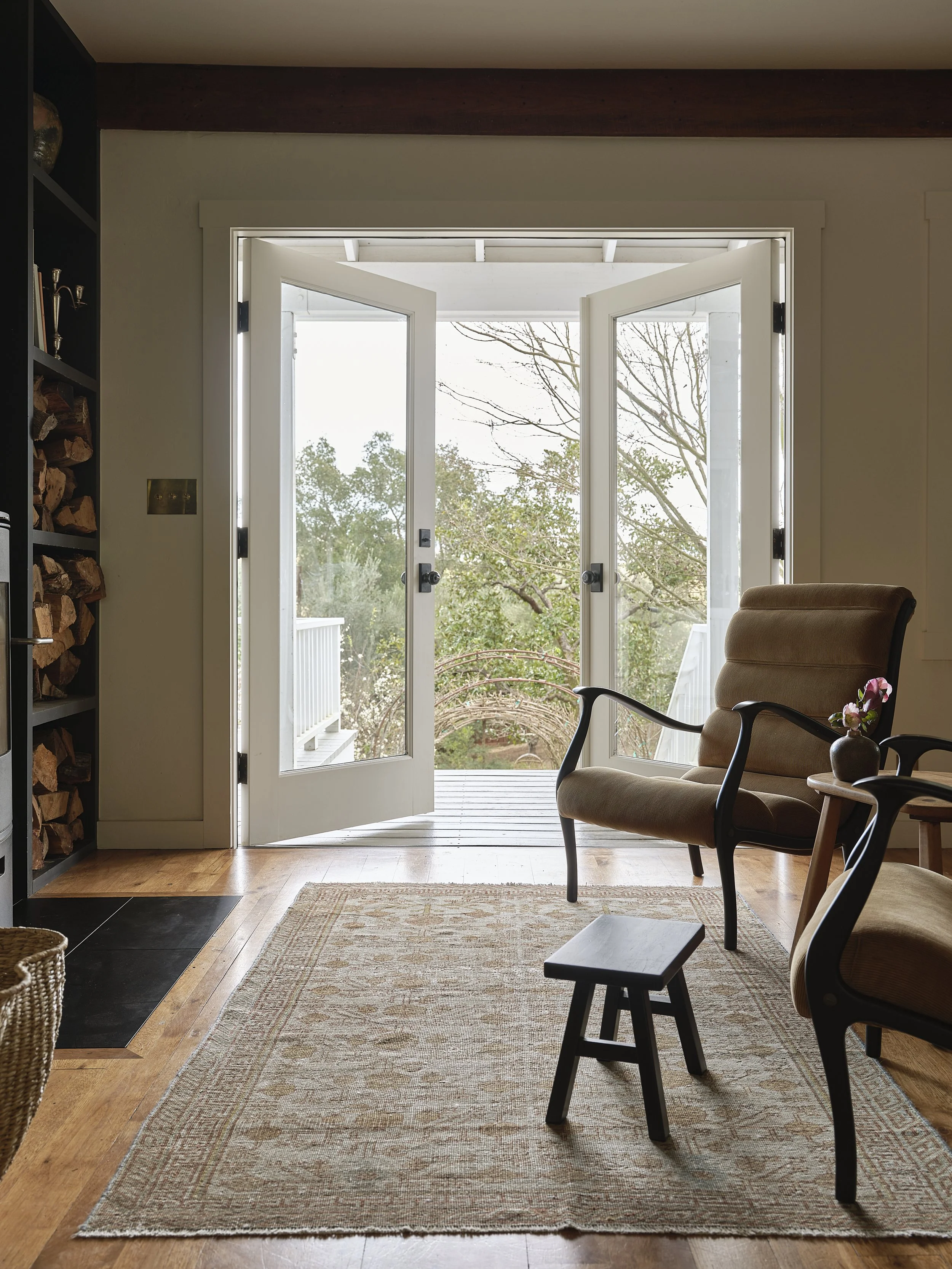 Fireplace and seating in front of open door to exterior.